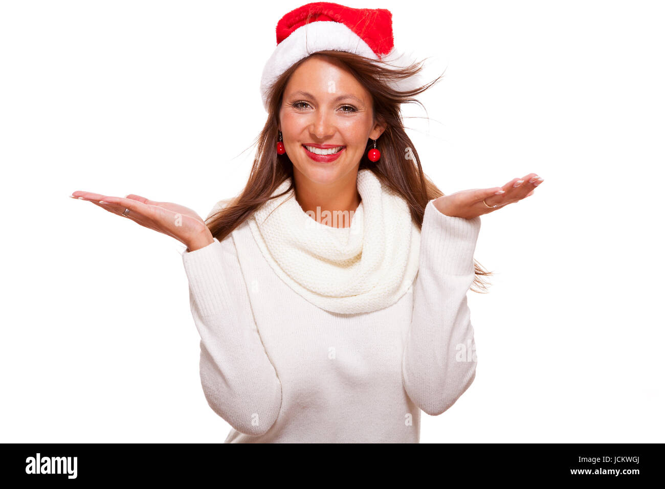 Junge Frau mit Nikolausmütze zeigt mit ihren Händen in die Luft auf Textfreiraum Präsentation saisonaler Produkte isoliert auf Weißem Hintergrund Freisteller Stock Photo