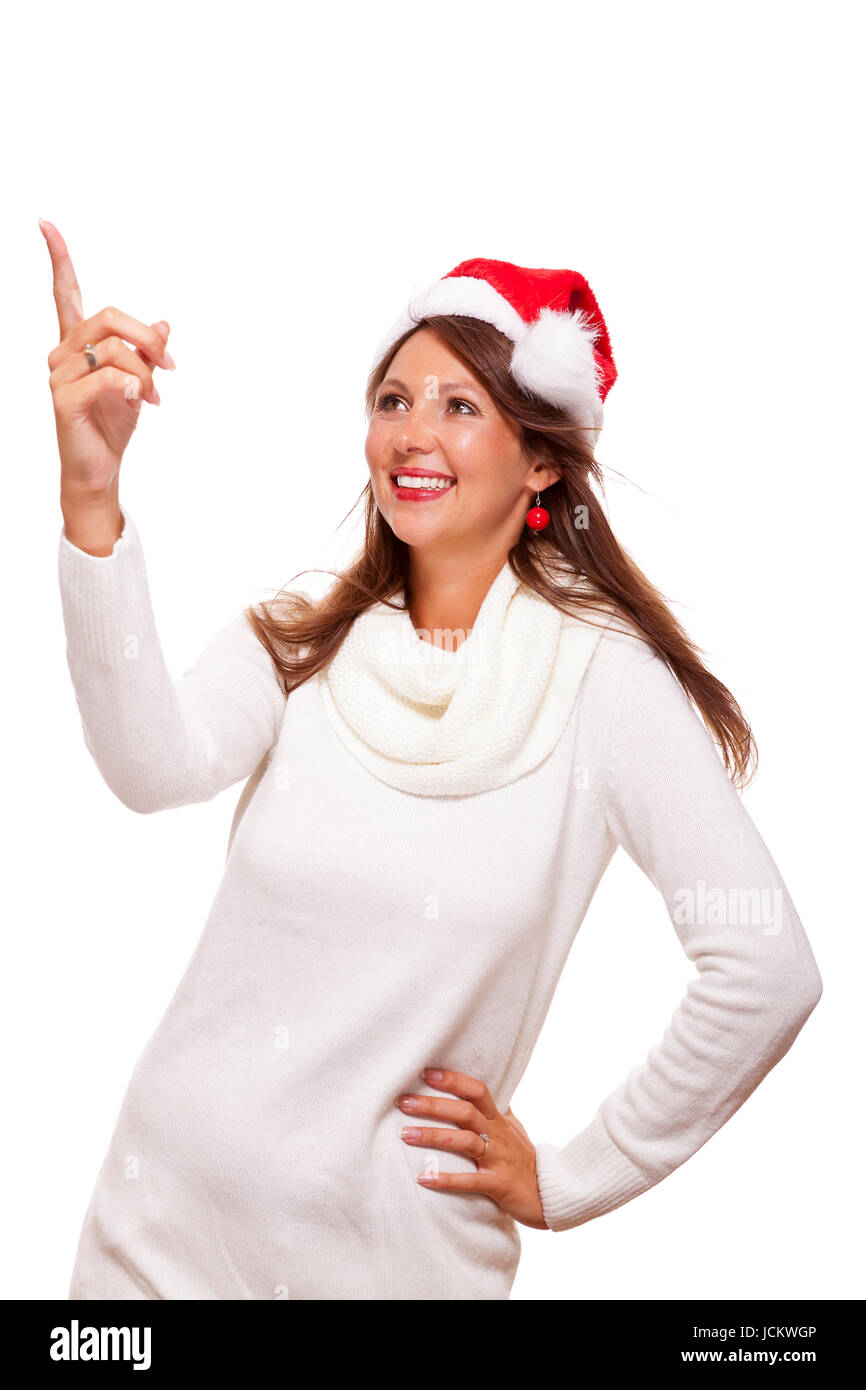 Junge Frau mit Nikolausmütze zeigt mit ihren Händen in die Luft auf Textfreiraum Präsentation saisonaler Produkte isoliert auf Weißem Hintergrund Freisteller Stock Photo