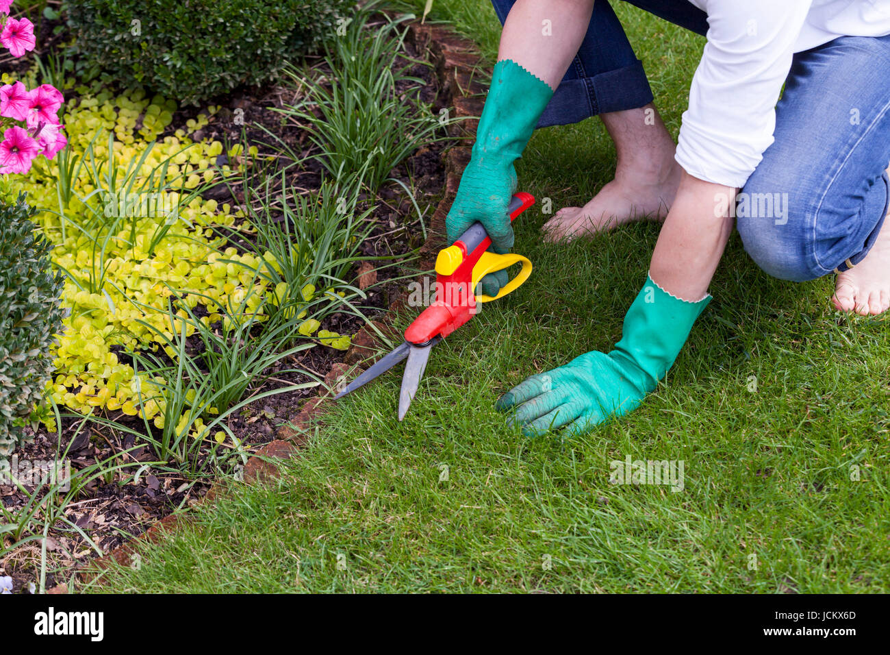 Hände mit Handschuhen und einer Gartenschere bei der Gartenarbeit im Sommer im Freien Stock Photo