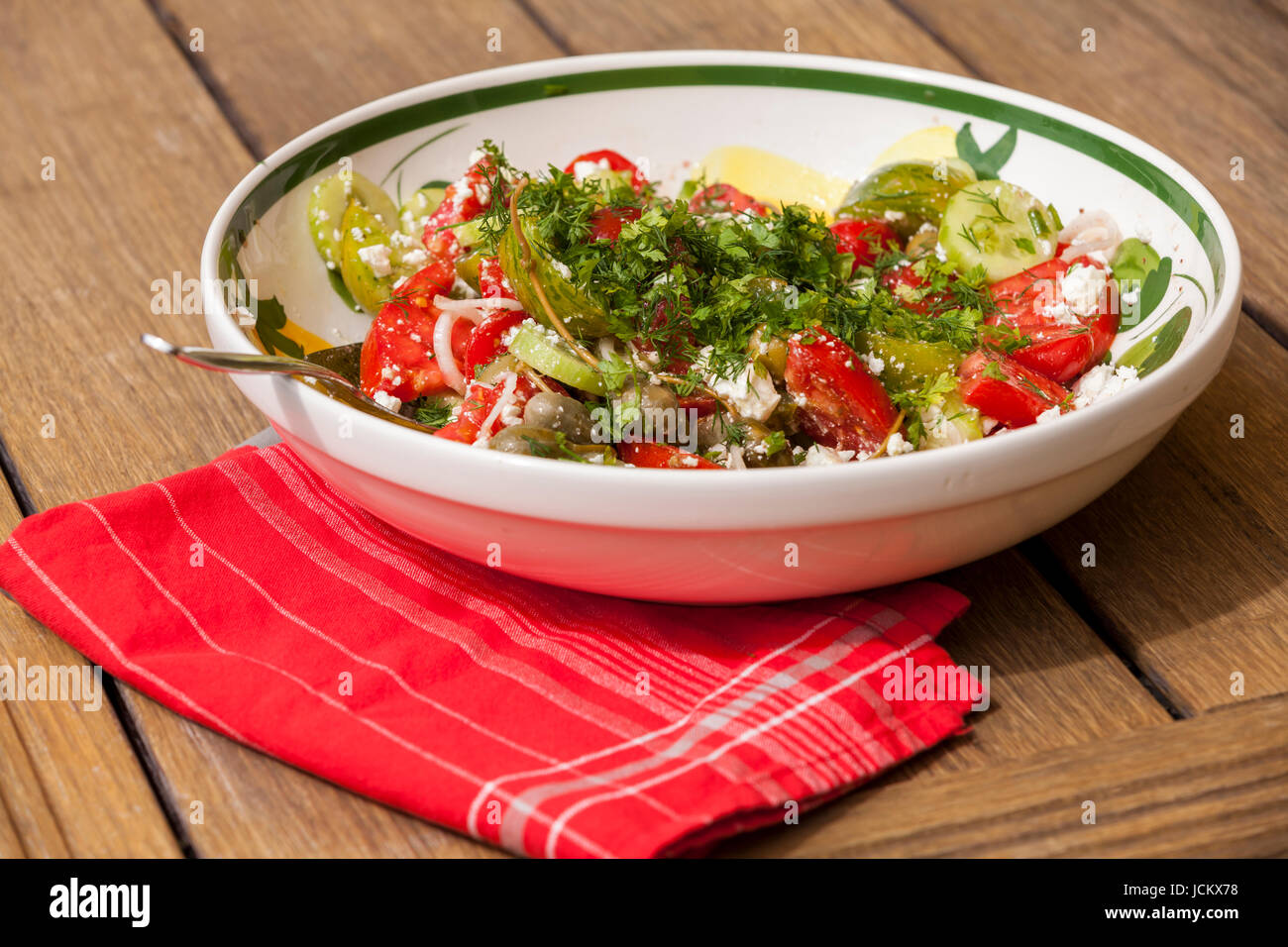 Schüssel mit mariniertem griechischen Salat mit Tomaten käse und oliven auf einem holz untergrund Stock Photo