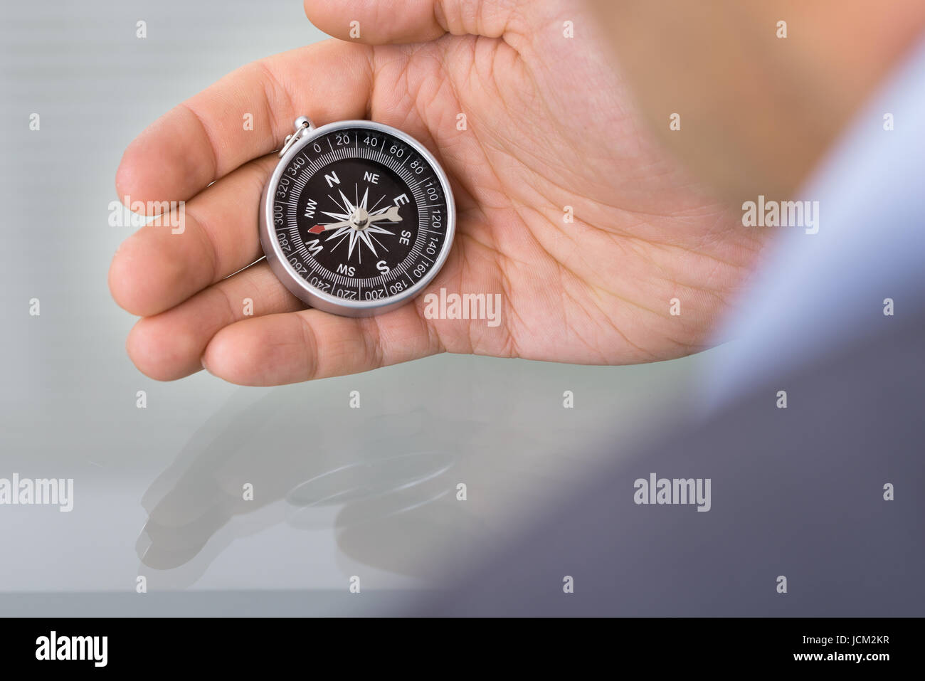 Business advisor holding compass. Over the shoulder view Stock Photo