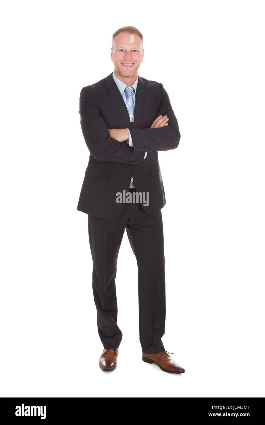 Full length portrait of happy businessman standing arms crossed ...