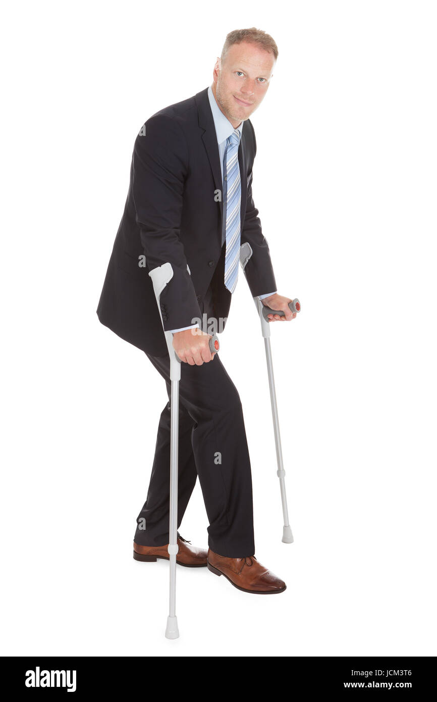 Full Length Portrait Of Mid Adult Businessman Walking With Crutches ...