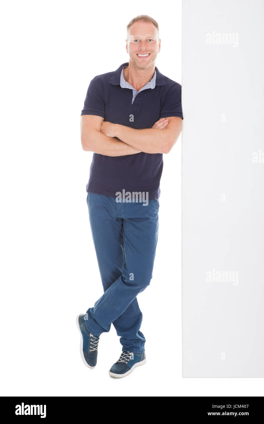 Full length portrait of smiling mid adult man standing arms crossed ...