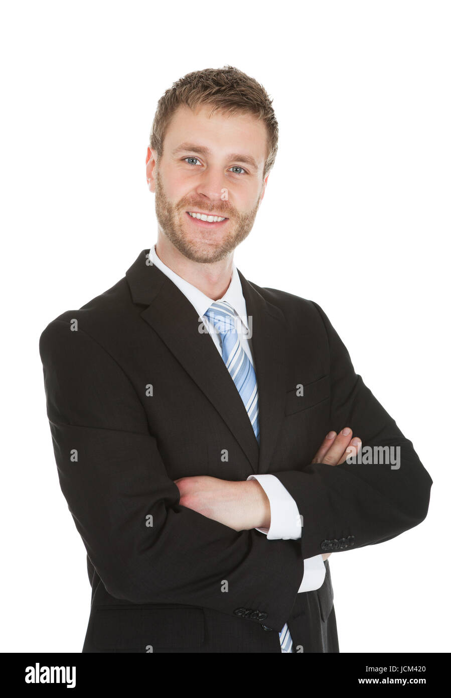 Portrait of smiling young businessman standing arms crossed over white ...