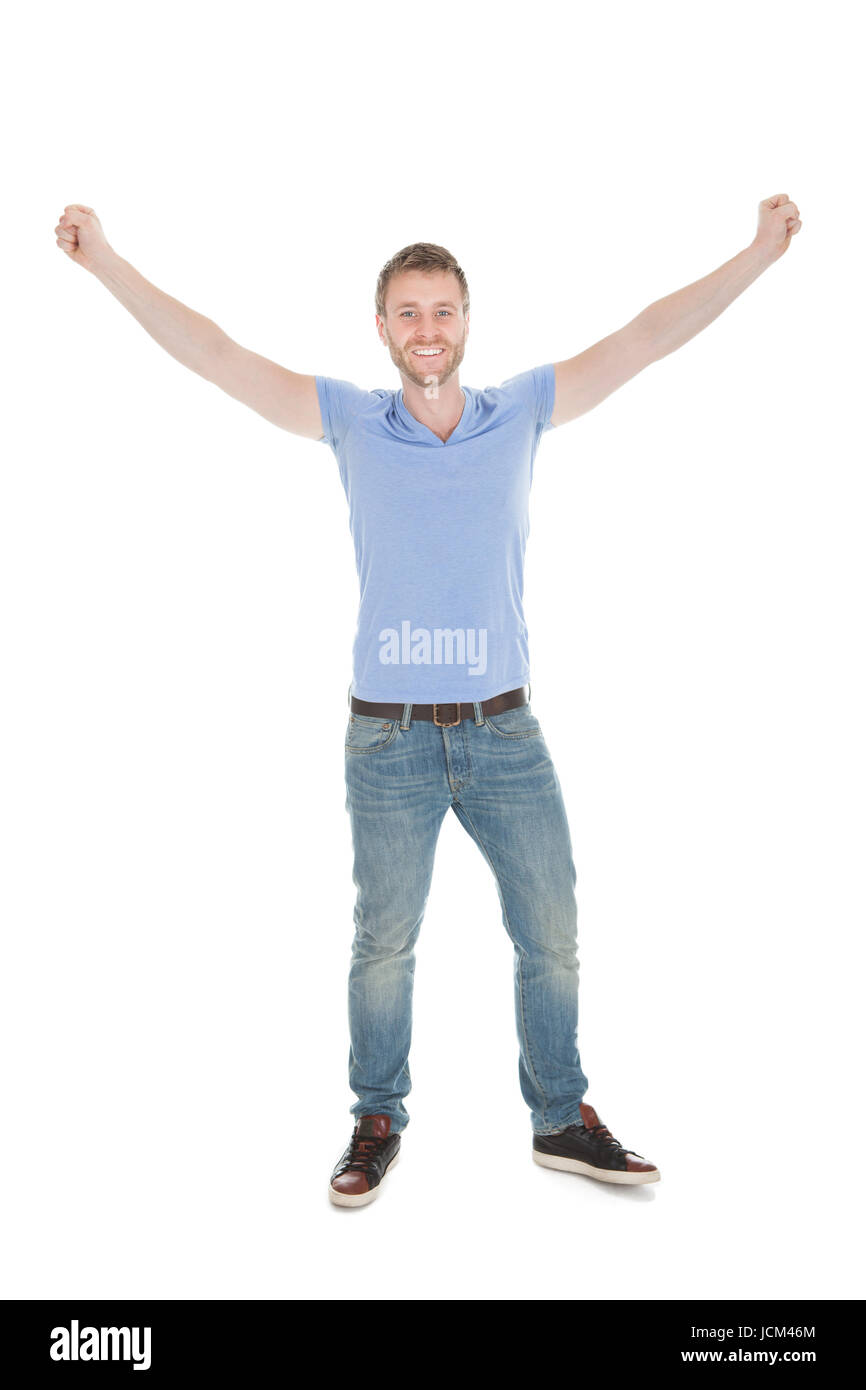 Portrait of cheerful young man with hands raised standing isolated on ...