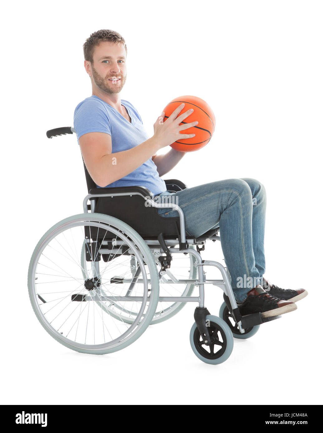 Full length portrait of disabled player holding basketball on wheelchair over white background Stock Photo