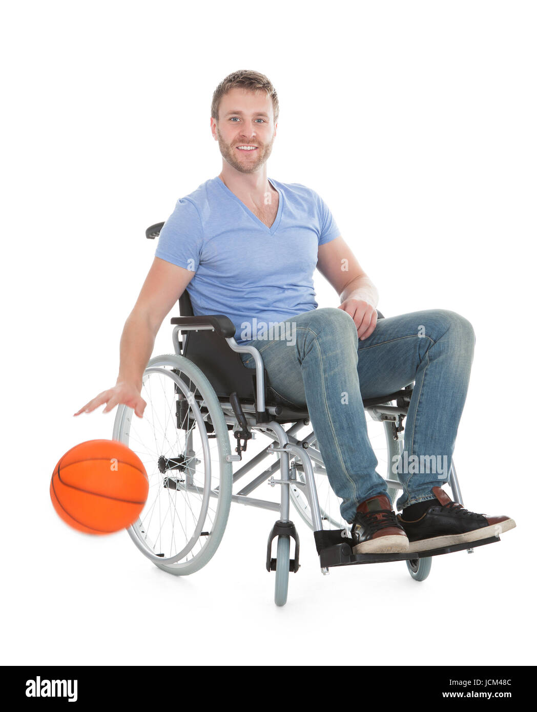 Full length portrait of disabled player holding basketball on wheelchair over white background Stock Photo