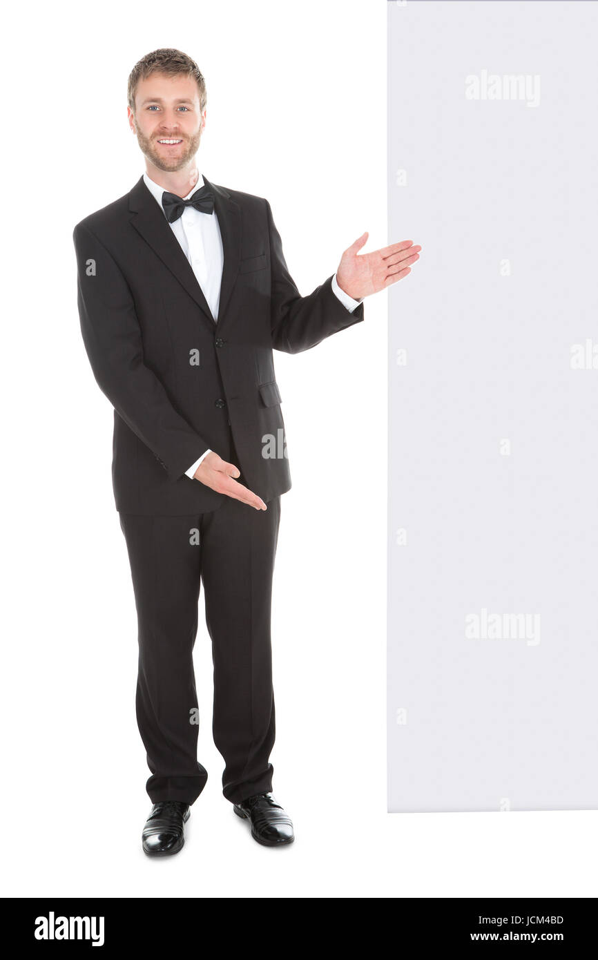 Young butler looking at blank billboard isolated over white background