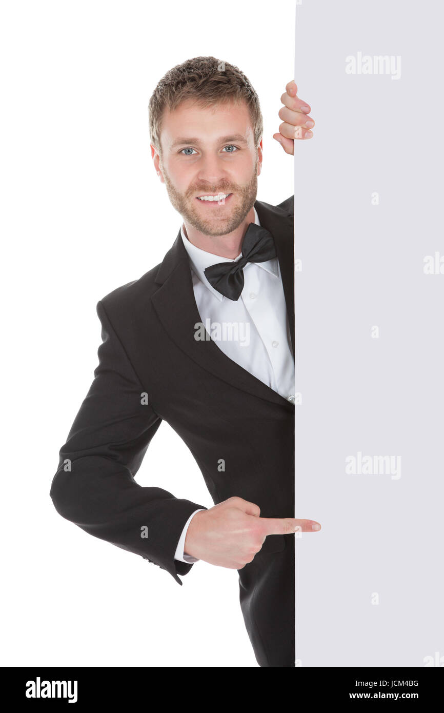 Young butler looking at blank billboard isolated over white background