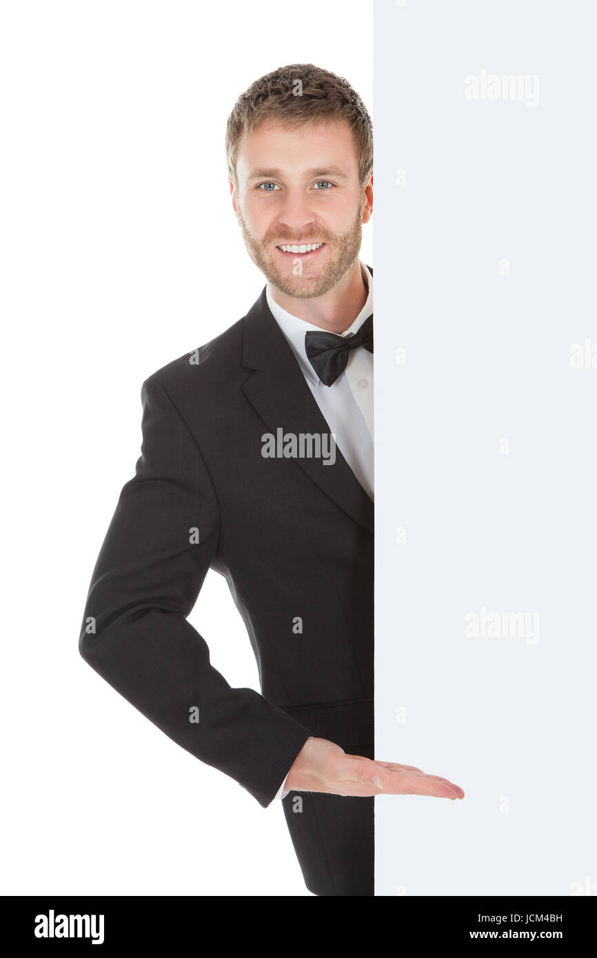 Young butler looking at blank billboard isolated over white background