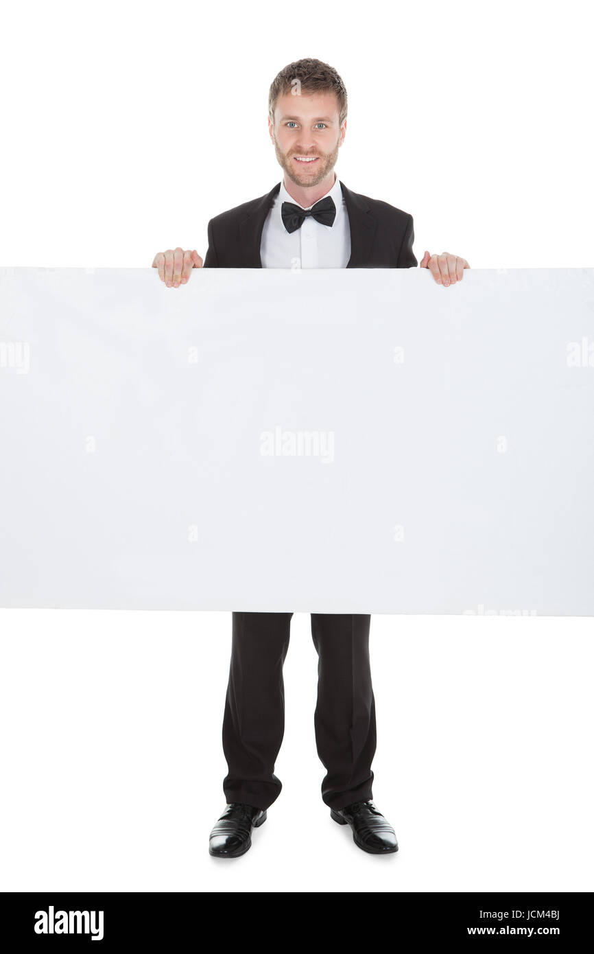 Young butler looking at blank billboard isolated over white background