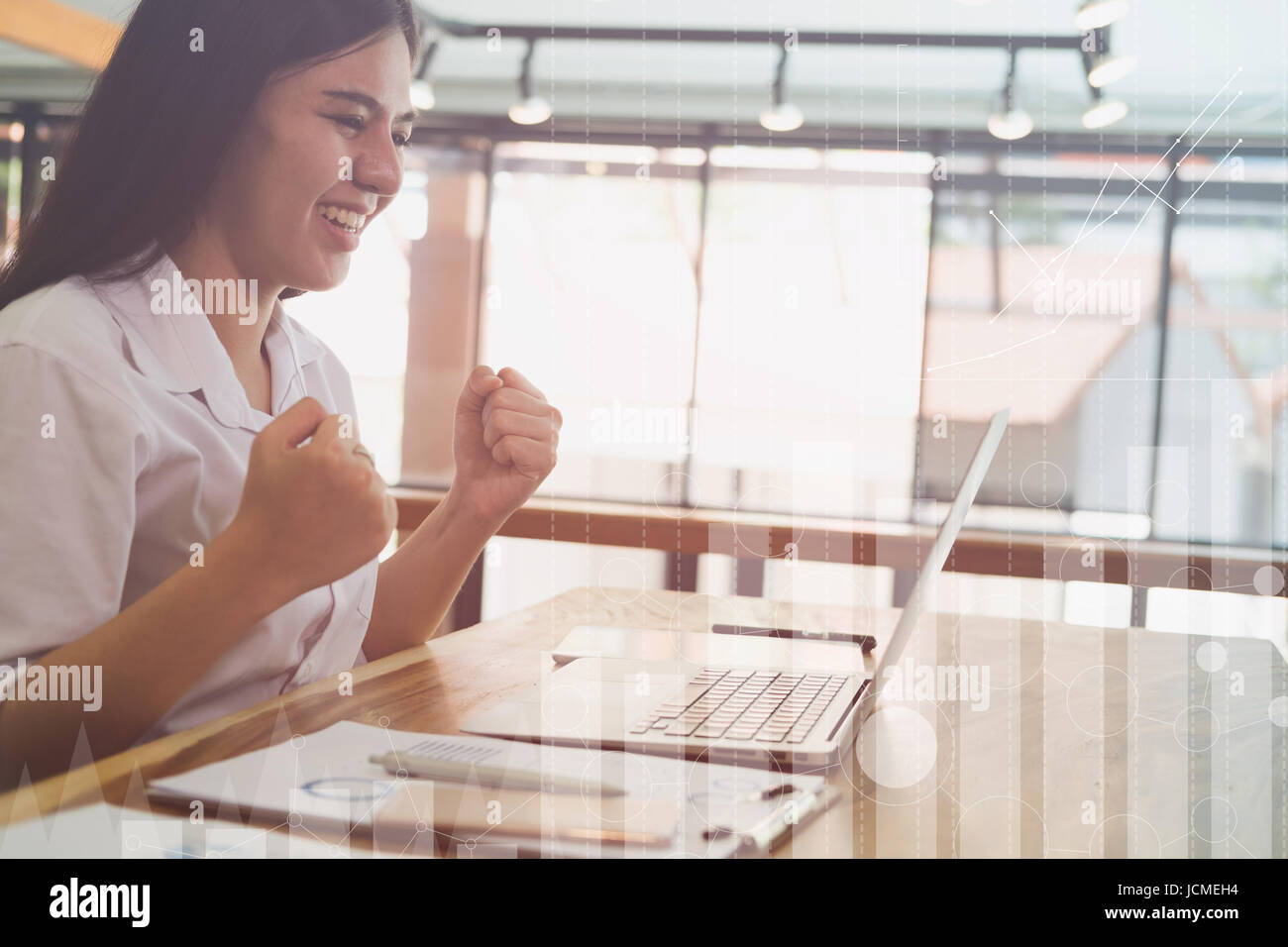 successful businesswoman working in the office. happy female start up woman smile and gesture with her fists showing gladness and satisfying Stock Photo