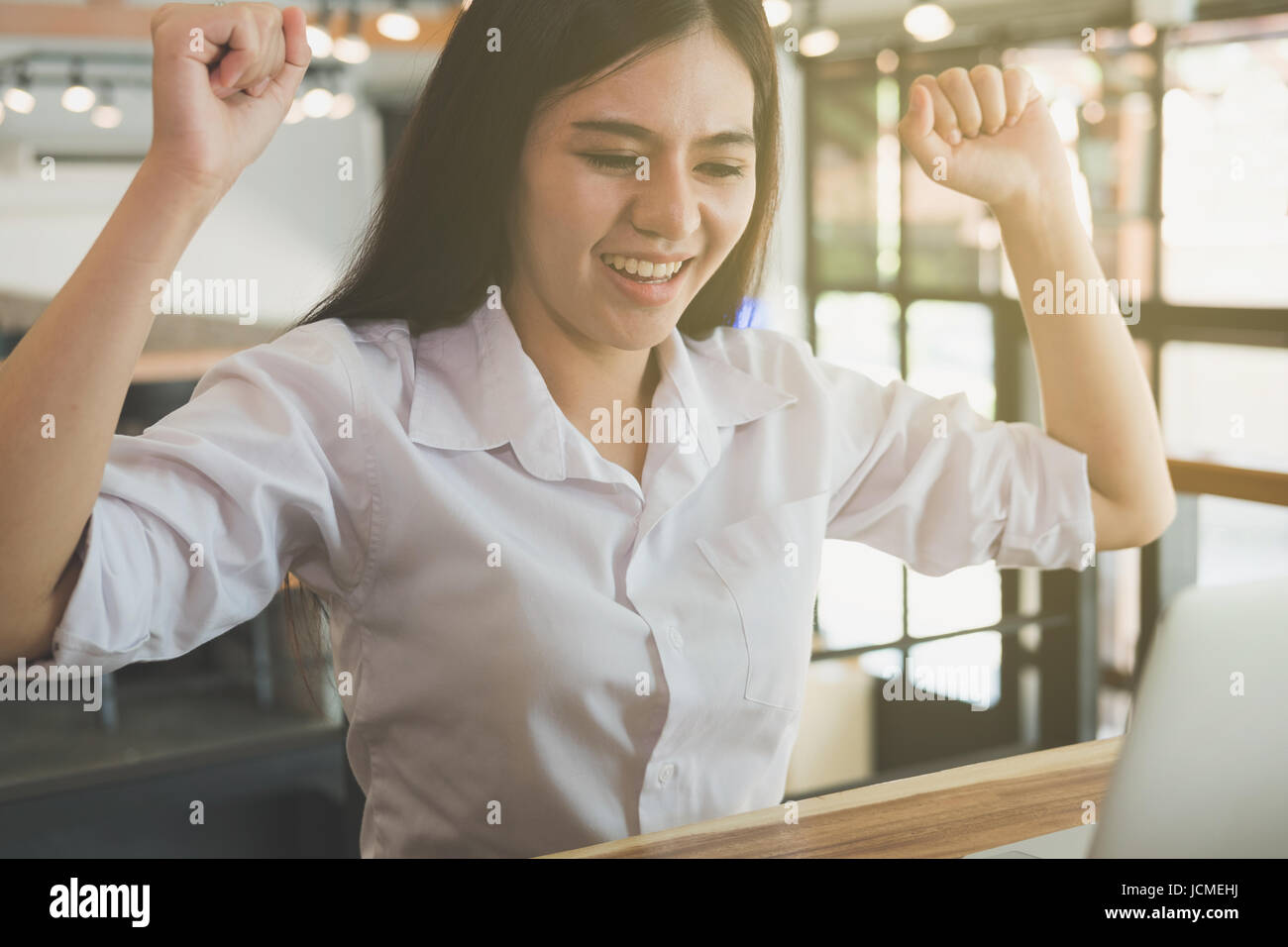 successful businesswoman working in the office. happy female start up woman smile and gesture with her fists showing gladness and satisfying Stock Photo