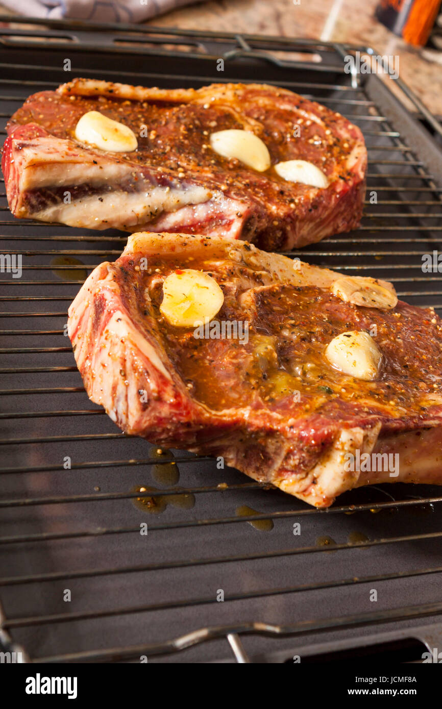 mariniertes Rindfleisch zum Grillen mit Paprika knoblauch und öl in einer Küche als Nahaufnahme Stock Photo