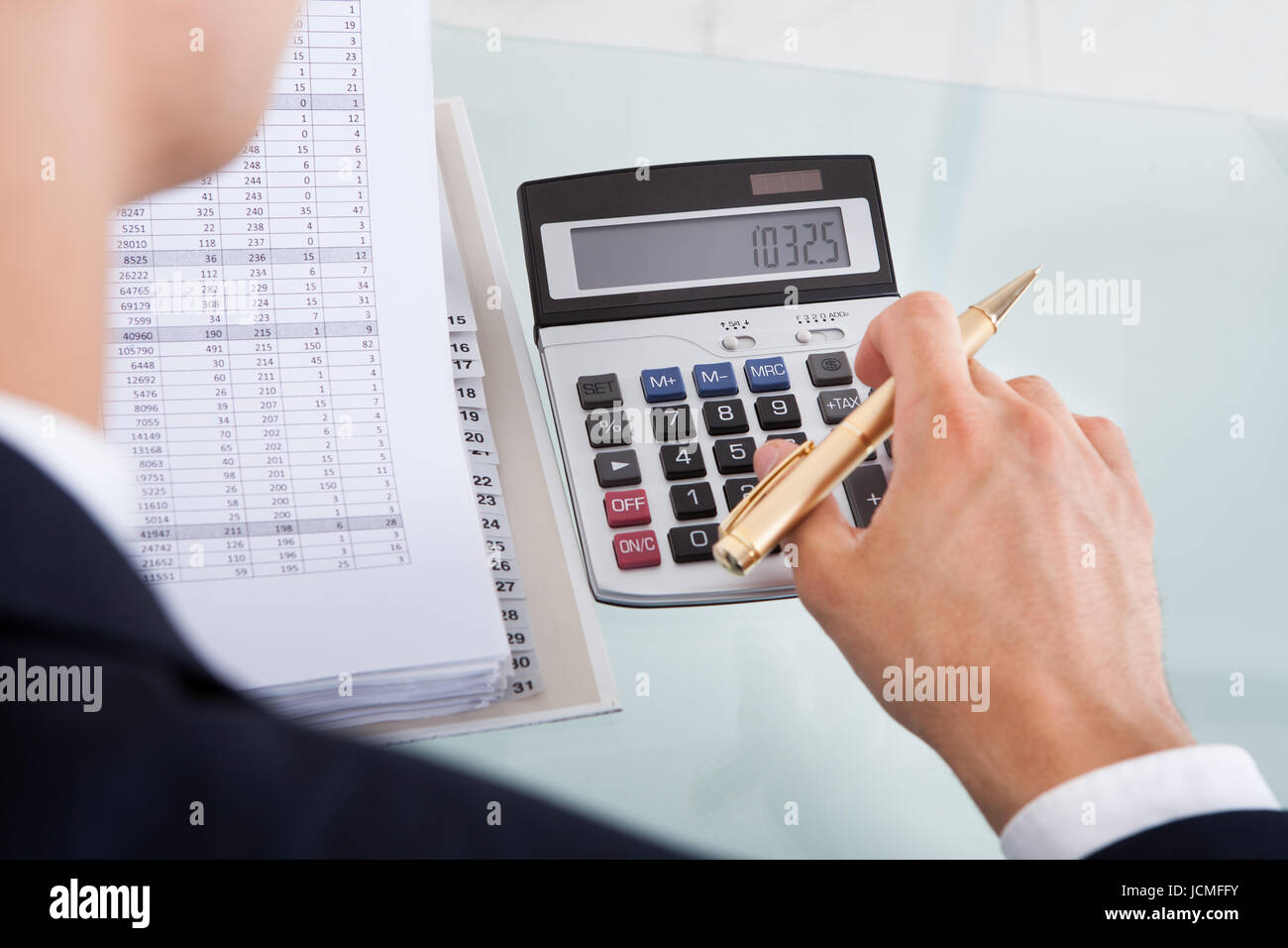 Cropped image of businessman calculating expense at desk in office