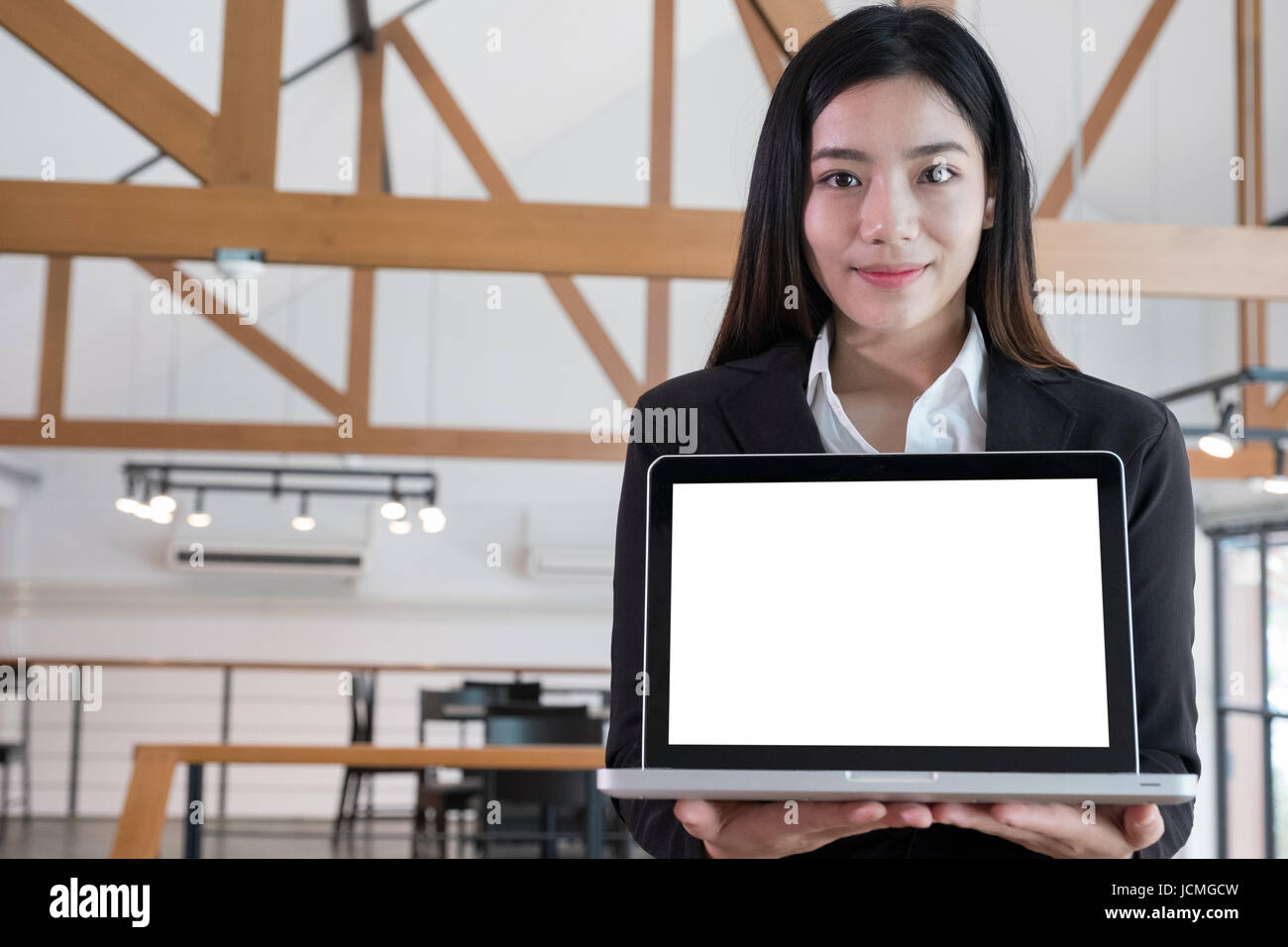 Young asian business woman smiling and showing blank laptop computer ...