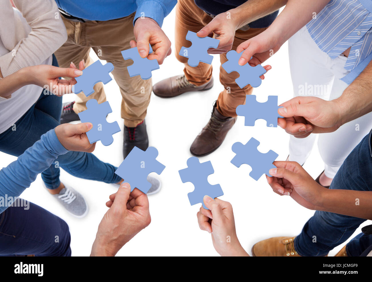 High Angle View Of People Connecting Puzzle Pieces Over White high-angle-view-of-people-connecting-puzzle-pieces-over-white