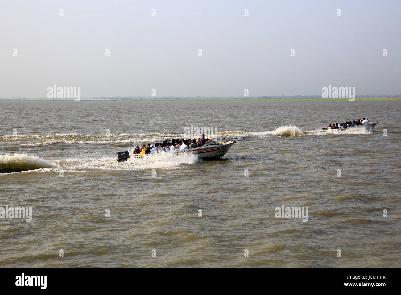 People cross the Padma River on speedboats on the Maowa-Kaorhakandi route without putting life jackets. Munshiganj, Bangladesh Stock Photo