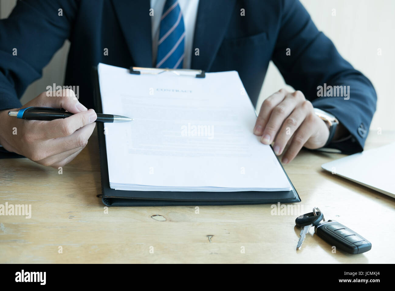young businessman present signing sales contract with car key to customer at office. ownership, customer buying and salesman selling transportation co Stock Photo