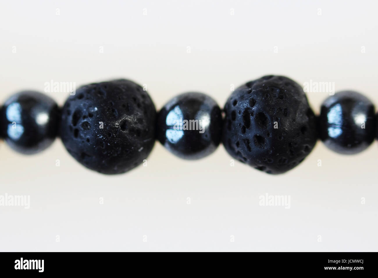 Necklace from black vesuvian Vesuvius and hematite. Macro shot on white background. Stock Photo