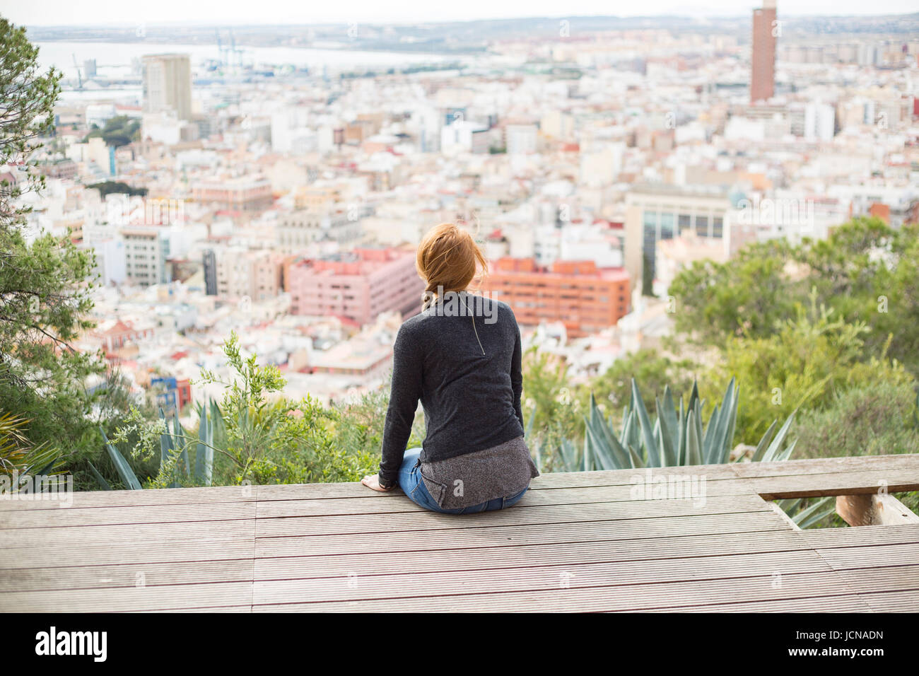 Young woman looking out over the city. Alicante in Spain Stock Photo
