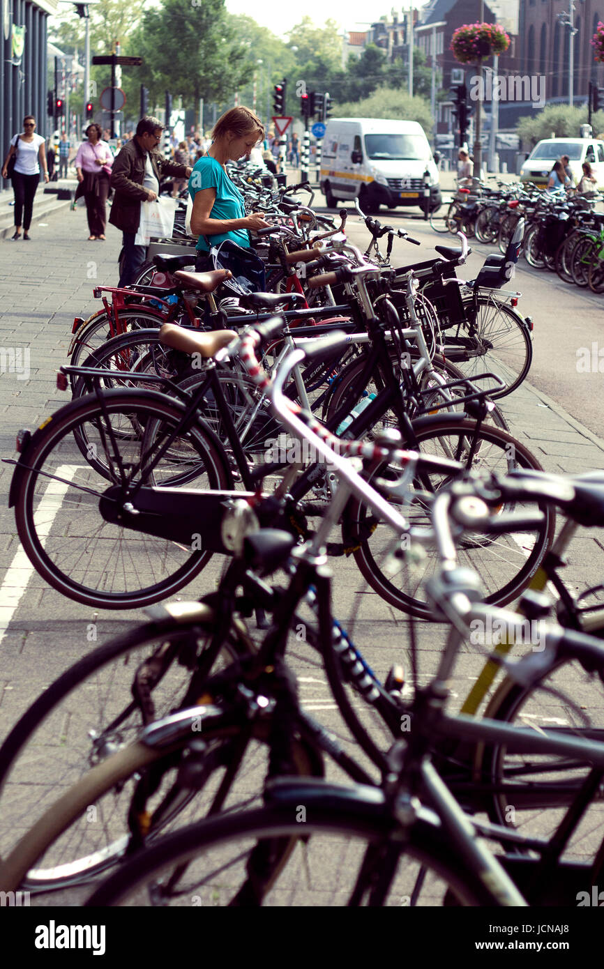 Young Woman locking her bike in Amsterdam. Stock Photo