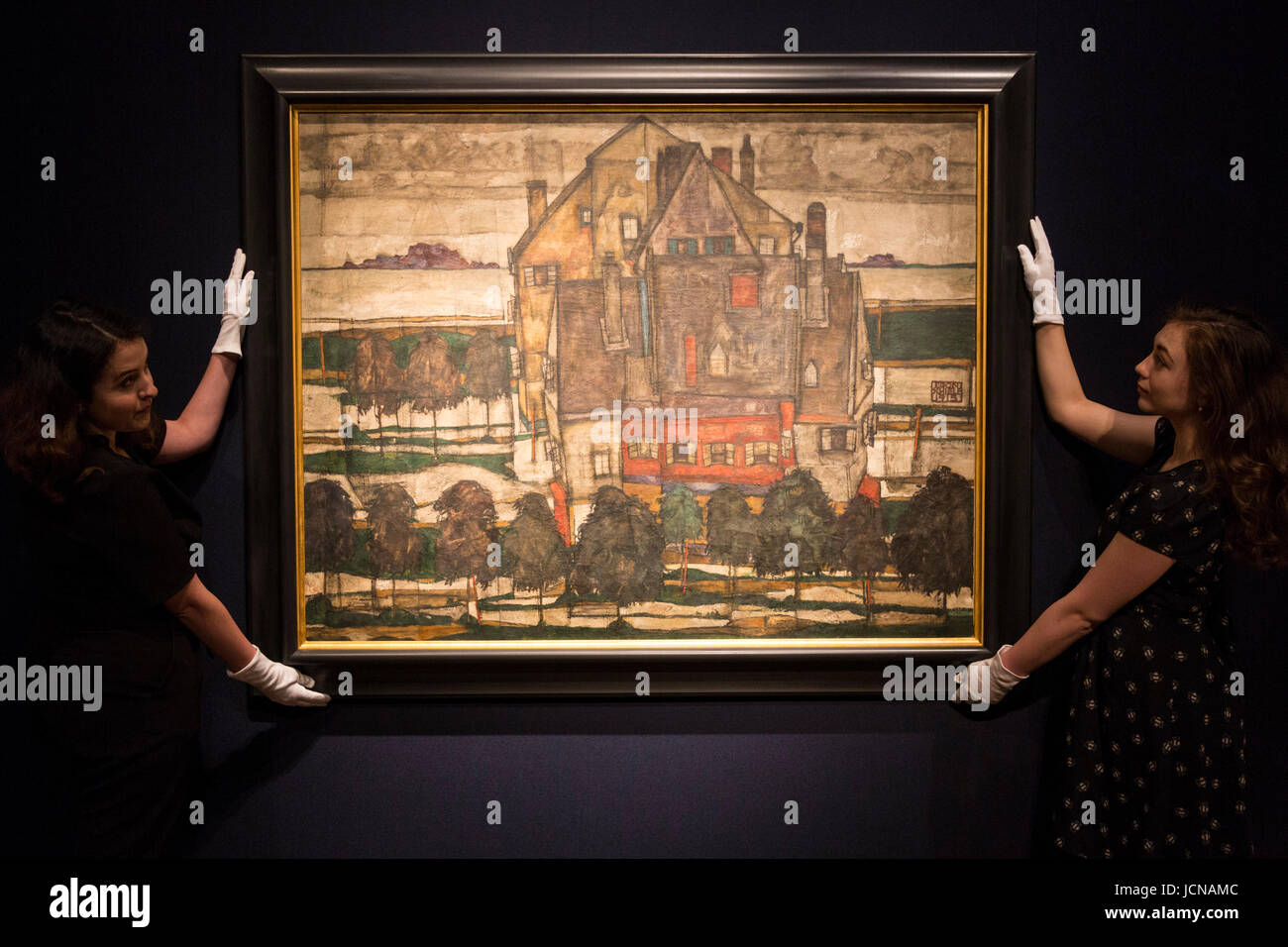 London, UK. 16 June 2017. Christie's employees handling the painting Einzelne Haeuser (Haeuser mit Bergen), 1915, by Egon Schiele, est. GBP 20-30m. Auction house Christie's presents a preview of the Impressionist and Modern Art evening sale on 27 June 2017. The sale is part of 20th Century at Christie's and is led by a group of masterpiece paintings by Max Beckmann, Claude Monet, Pablo Picasso, Egon Schiele and Vincent van Gogh. Stock Photo