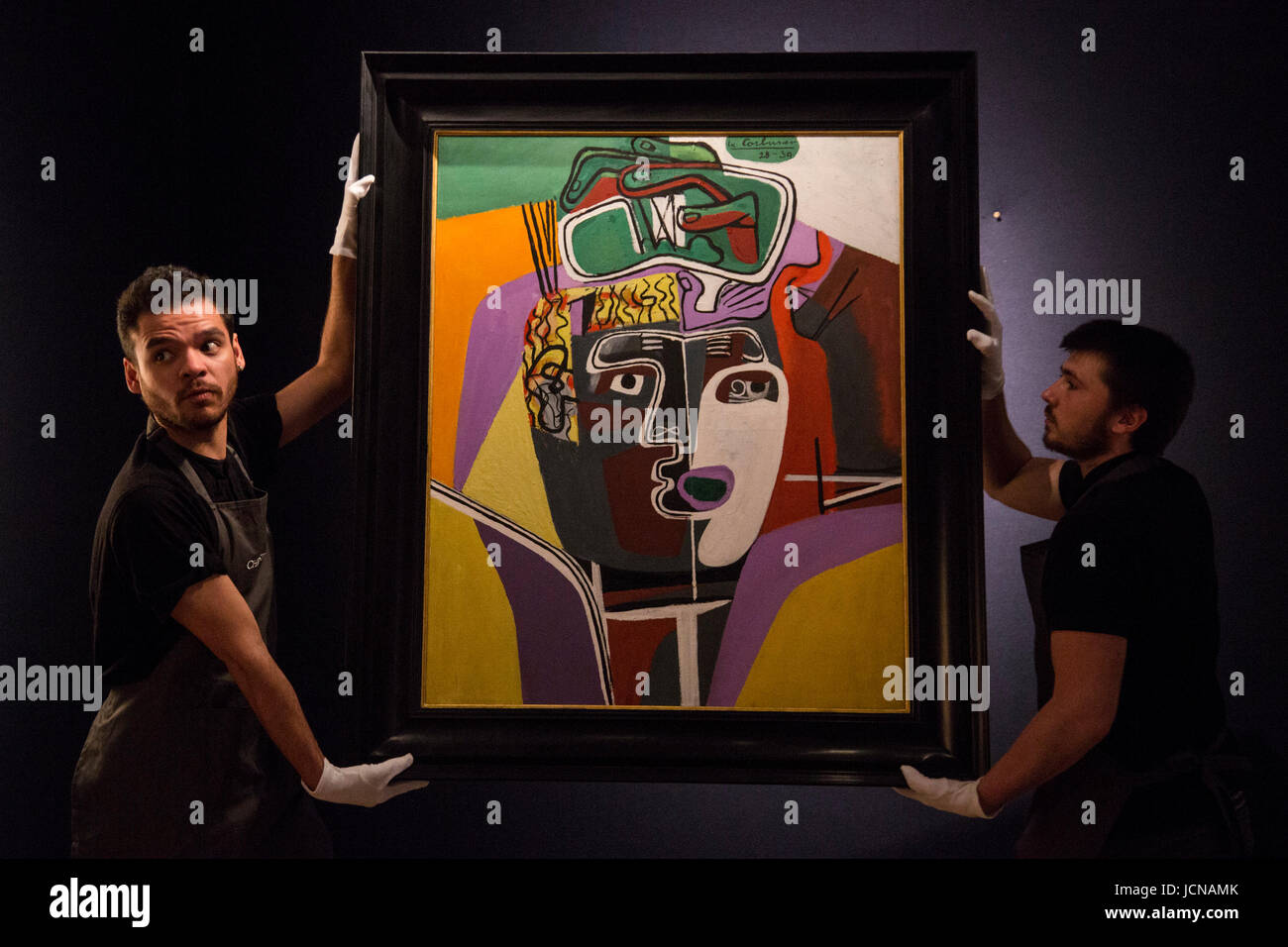 London, UK. 16 June 2017. Christie's technicians handling the painting Mains croisees sur la tete, 1939-40, by Le Corbusier, est GBP 1.2-2m which is influenced by Pablo Picasso. Auction house Christie's presents a preview of the Impressionist and Modern Art evening sale on 27 June 2017. The sale is part of 20th Century at Christie's and is led by a group of masterpiece paintings by Max Beckmann, Claude Monet, Pablo Picasso, Egon Schiele and Vincent van Gogh. Stock Photo