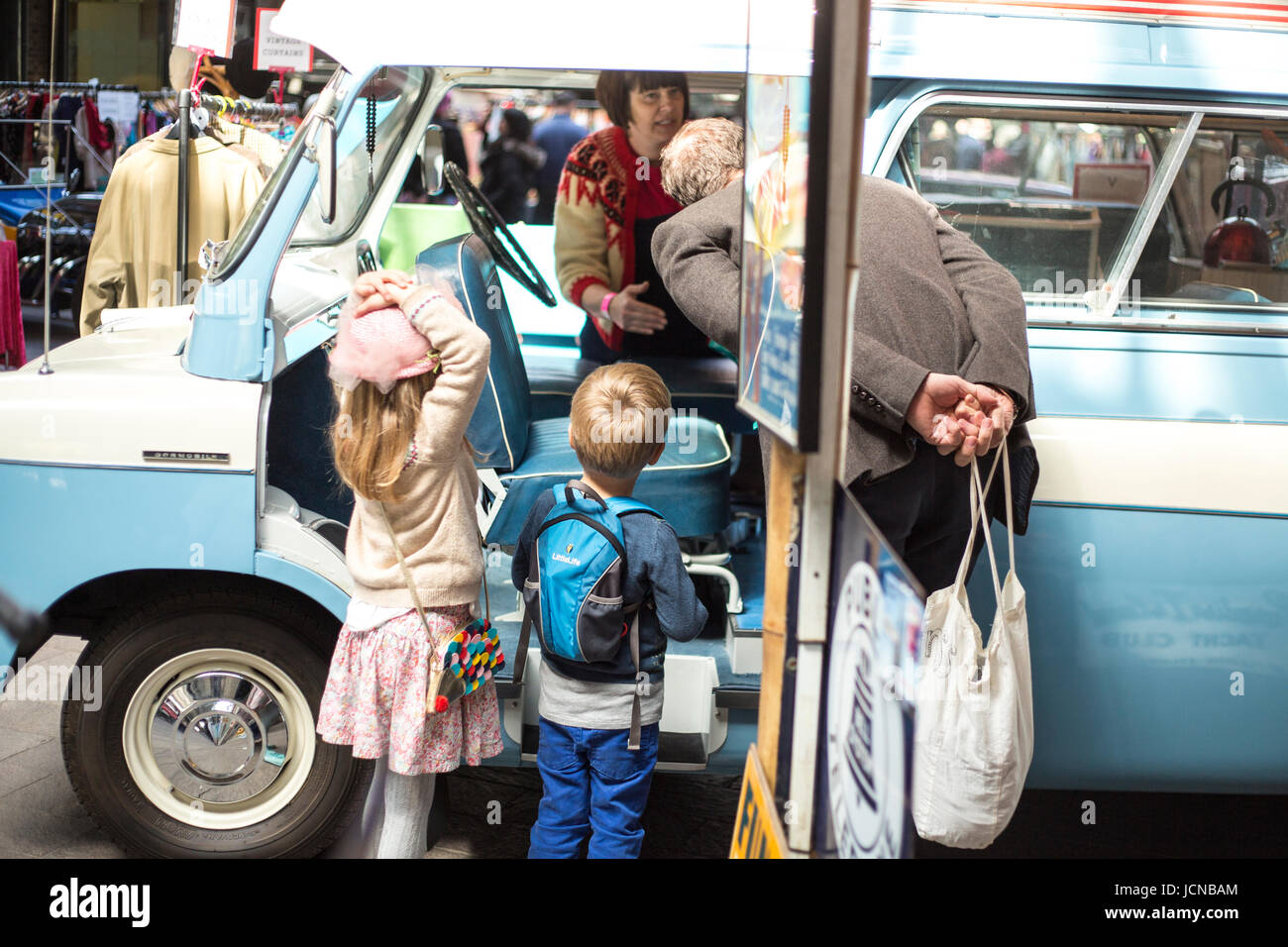 Old man and children look at vintage car in London. Stock Photo