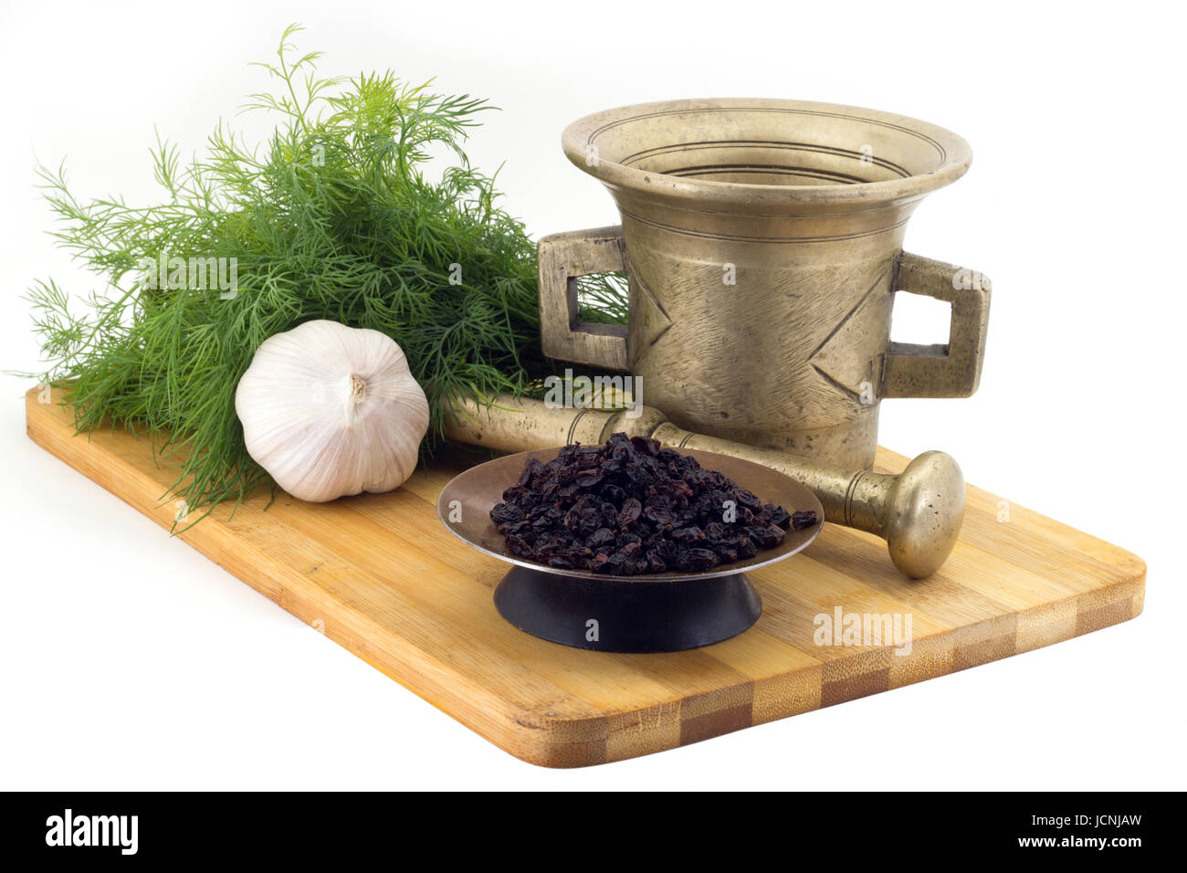 Still Life Spices,fragrant sumac ,marigold staminas in a copper vase on a wooden board on a background of a stern stupa for grinding spices, bunches o Stock Photo