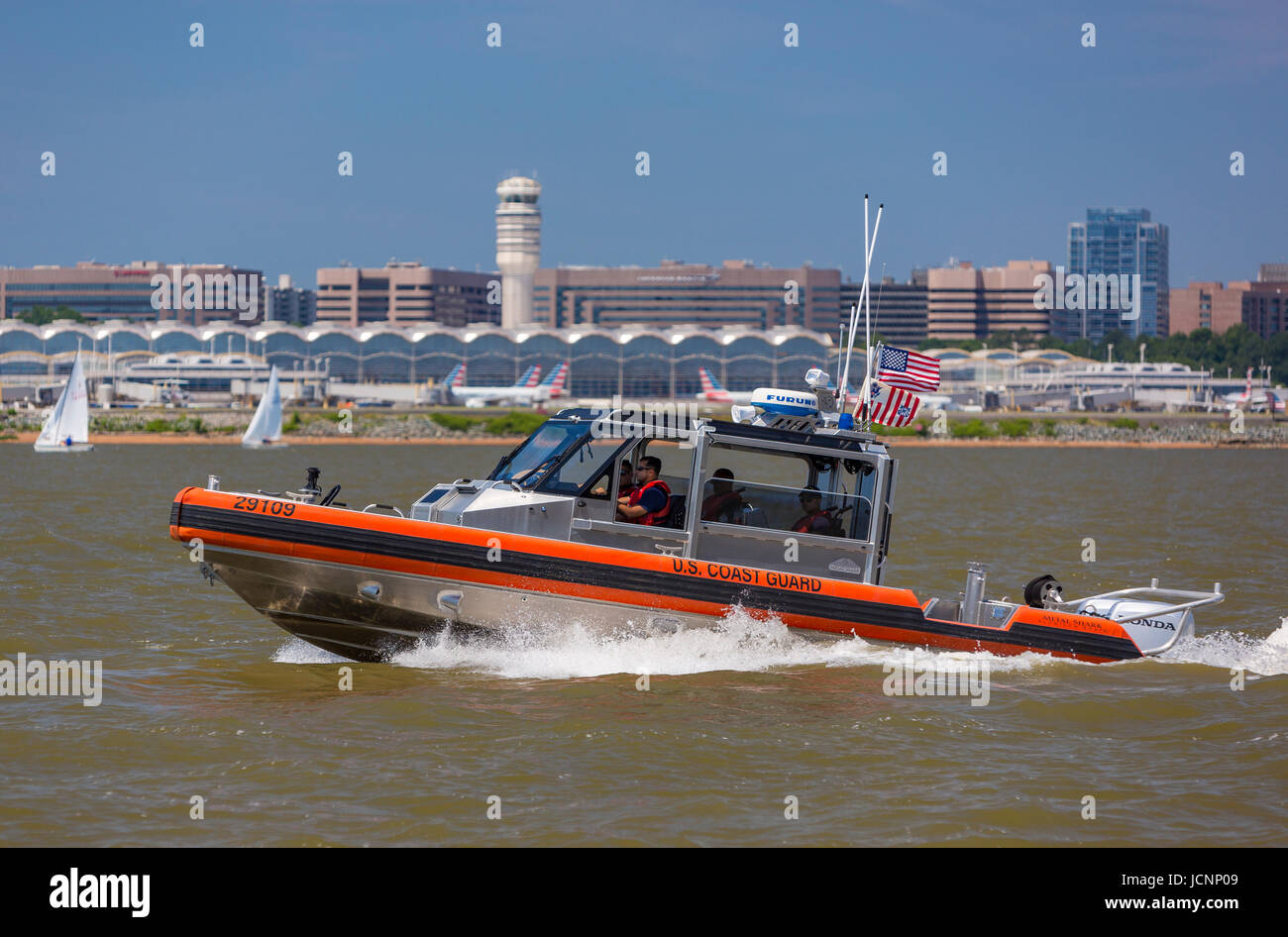 VIRGINIA, USA -  U. S. Coast Guard boat on Potomac River passes by Reagan National Airport, DCA. Stock Photo
