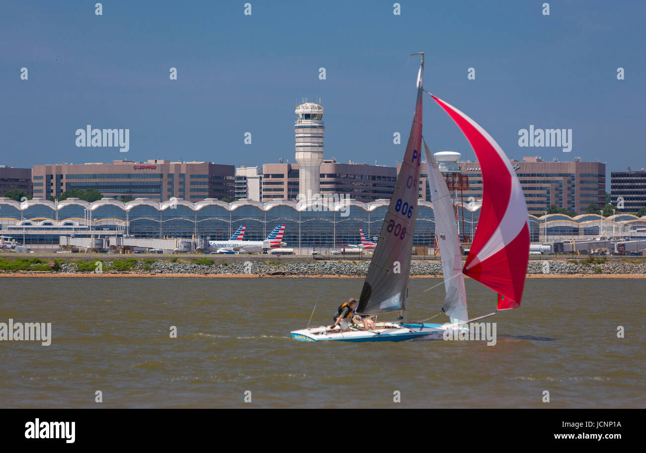 VIRGINIA, USA -  Sailboat on Potomac River passes by Reagan National Airport, DCA. Stock Photo