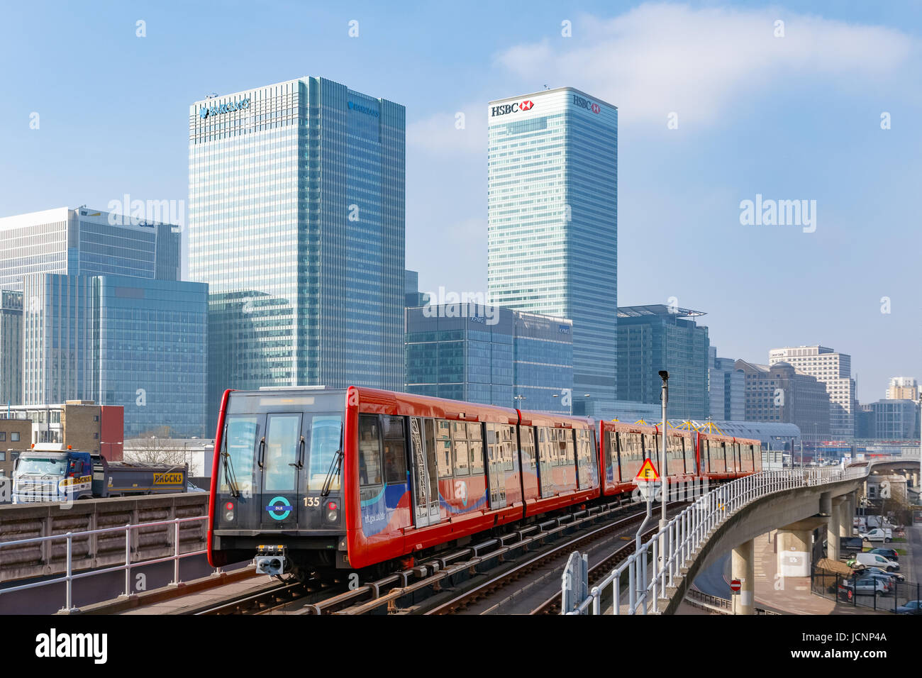 London, UK - March 27, 2017: Docklands Light Railway train with Canary Wharf in the background Stock Photo