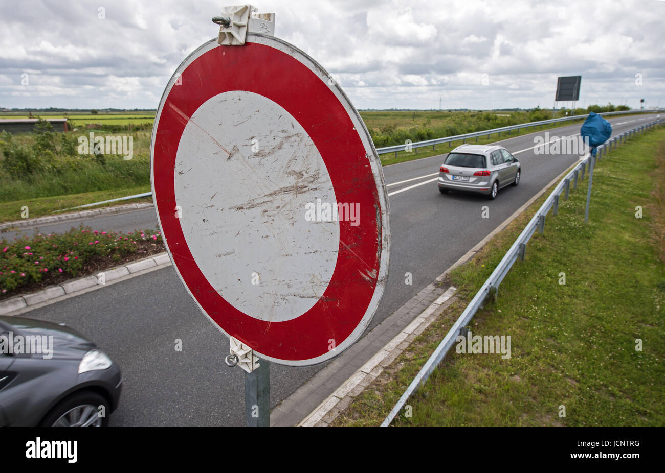 A 'Durchfahrt verboten' (lit. passage forbidden) sign stands at the eintrance of the bypass of Bensersiel, Germany, 16 June 2017. Now the traffic has to go through the narrow road of the coastal city again. Thereby the six-year-old illegaly built bypass finally was closed after a fierce lawsuit. Photo: Ingo Wagner/dpa Stock Photo
