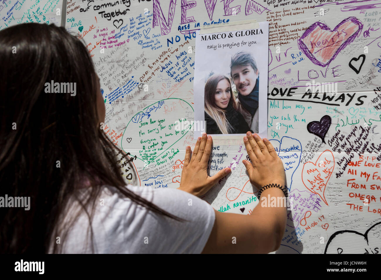 London, UK. 16th June, 2017. A young woman puts up a poster of missing friends. The Notting Hill community mourns the victims and comes together to help those who lost everything after the Grenfell Tower fire on Wednesday. Credit: Bettina Strenske/Alamy Live News Stock Photo