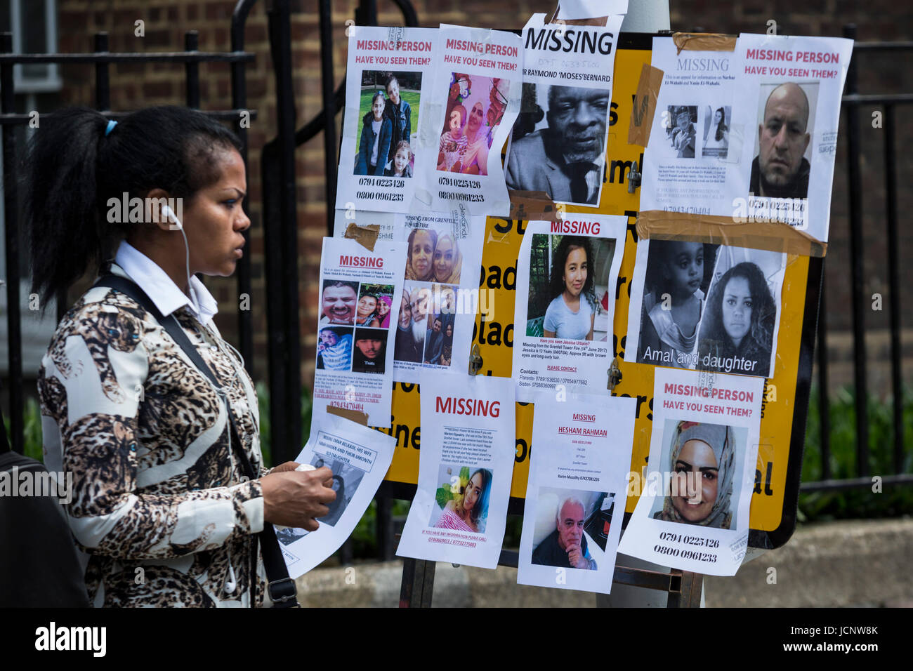 London, UK. 16th June, 2017. A woman looks a missing persons leaflets. The Notting Hill community mourns the victims and comes together to help those who lost everything after the Grenfell Tower fire on Wednesday. Credit: Bettina Strenske/Alamy Live News Stock Photo
