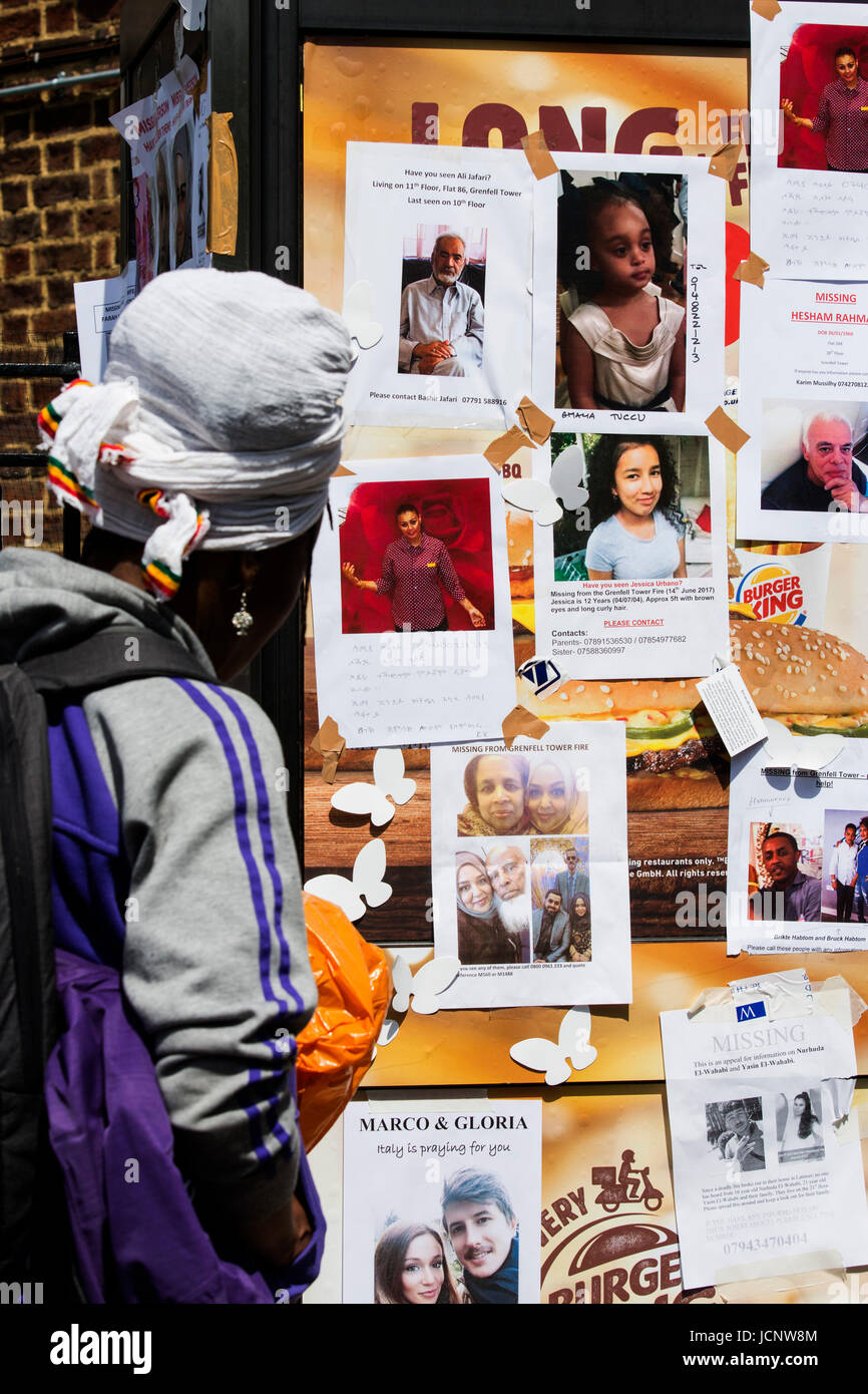 London, UK. 16th June, 2017. A woman looks a missing persons leaflets. The Notting Hill community mourns the victims and comes together to help those who lost everything after the Grenfell Tower fire on Wednesday. Credit: Bettina Strenske/Alamy Live News Stock Photo