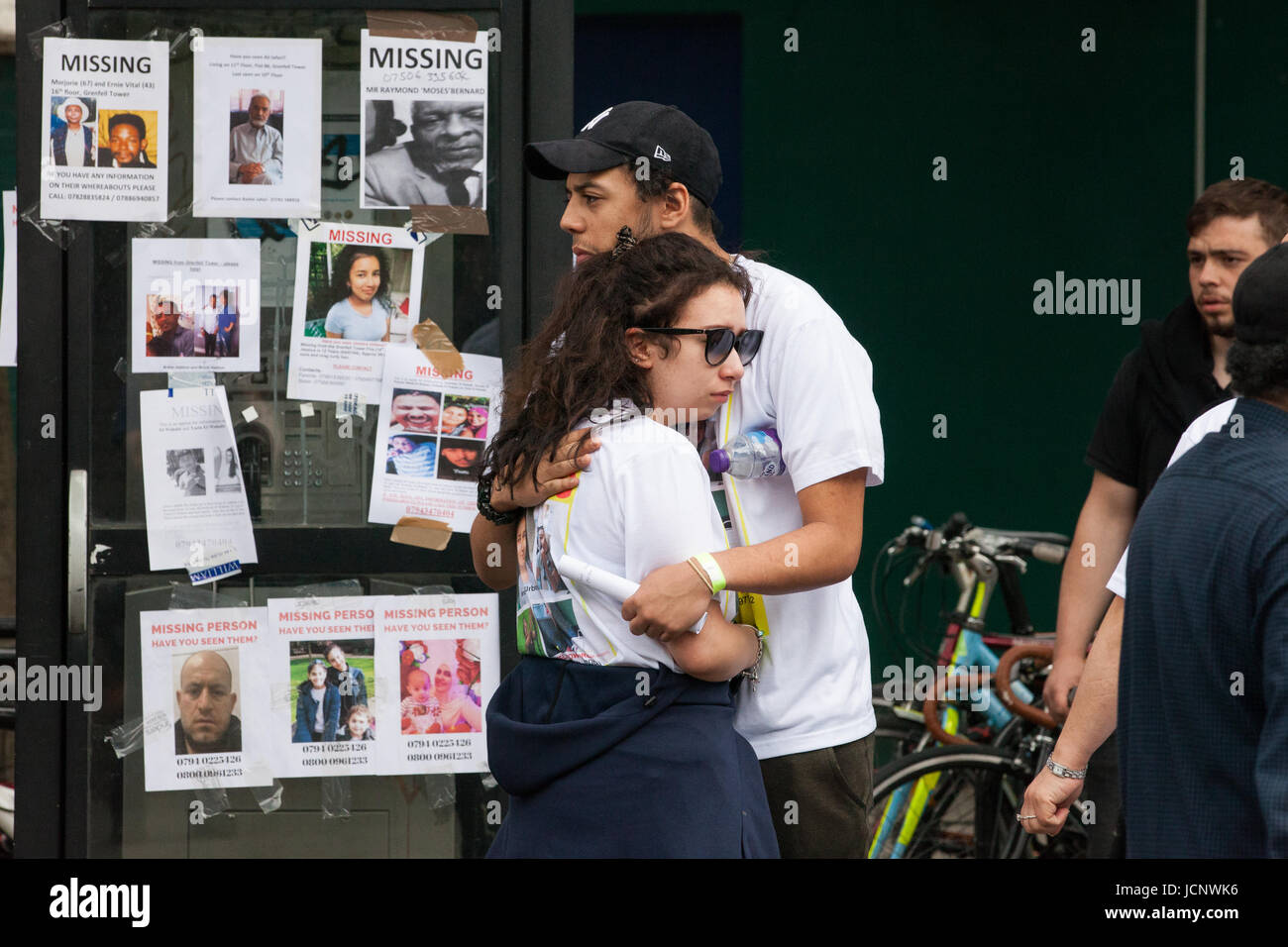 London, UK. 16th June, 2017. A man and a woman wearing missing person t-shirts comfort each other outside Latimer Road underground station. Credit: Mark Kerrison/Alamy Live News Stock Photo