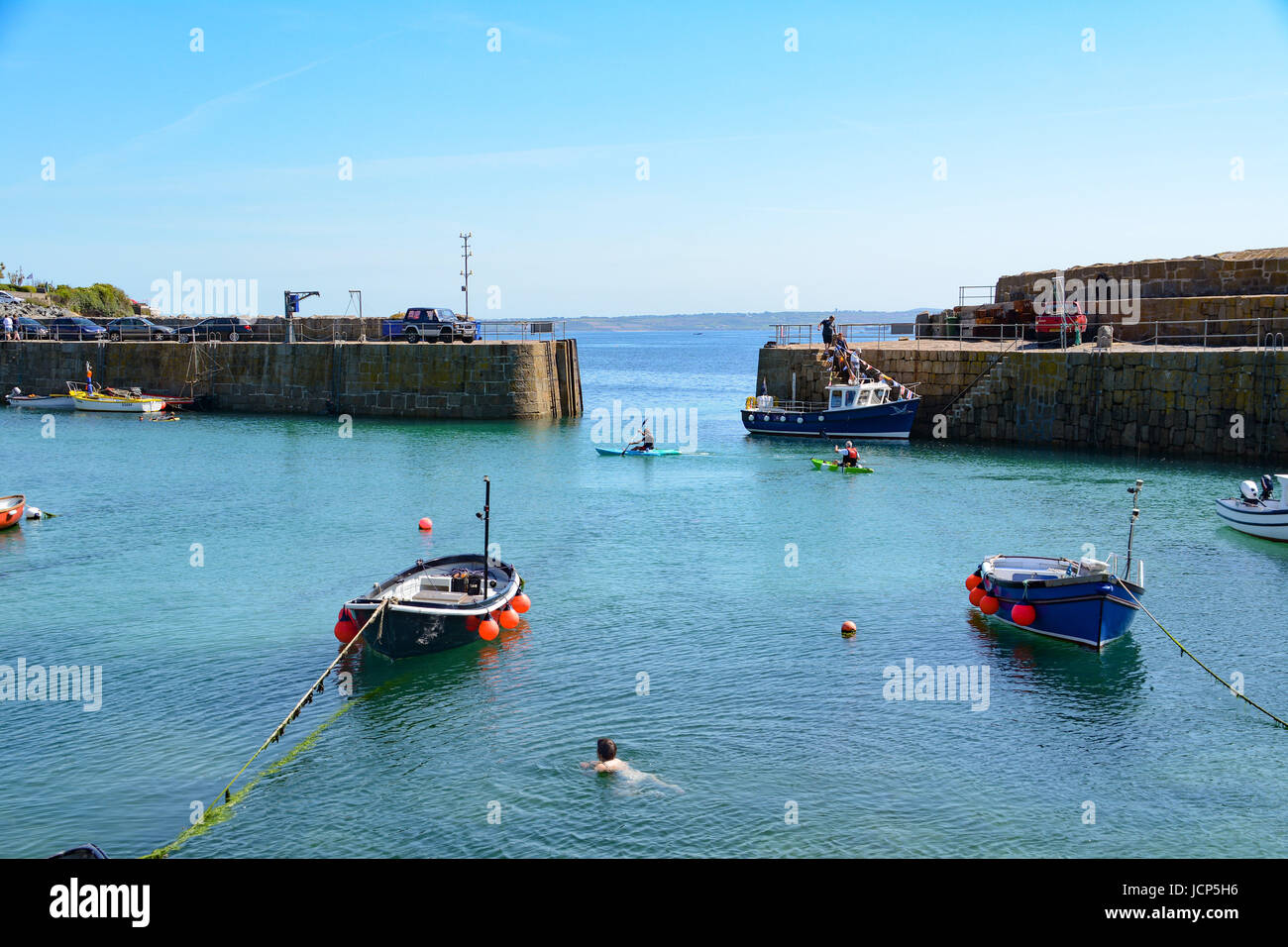 Mousehole, Cornwall, UK. 17th June, 2017. People enjoying the water and applying suncream on Saturday morning at Mousehole. Credit: cwallpix/Alamy Live News Stock Photo
