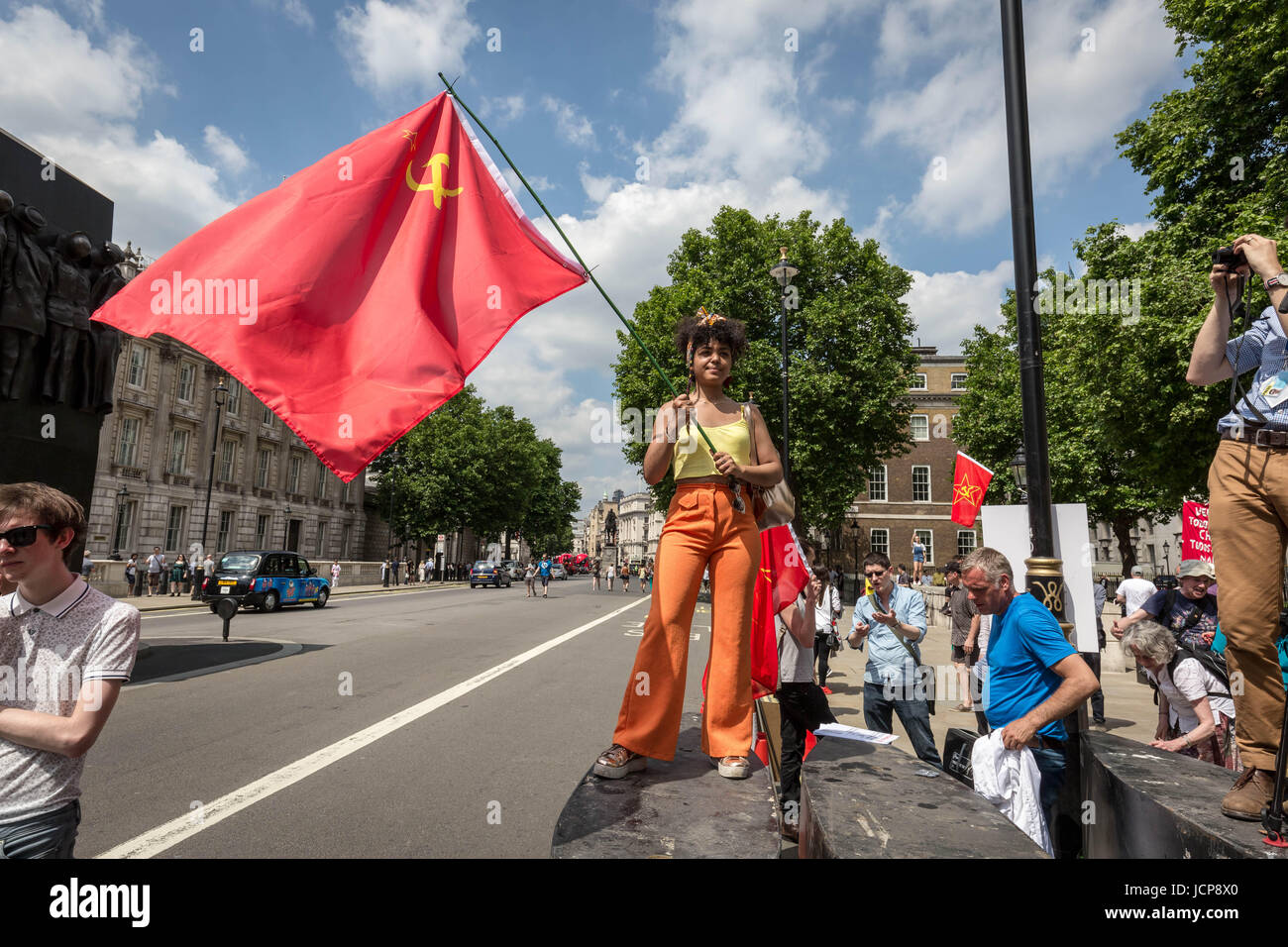 London, UK. 17th June, 2017. A young Venezuelan girl joins the anti-tory protest waving a communist flag in support of her fellow protesters battling the current political unrest in Caracas. Protest opposite Downing Street against PM Theresa May and Tory party DUP coalition. © Guy Corbishley/Alamy Live News Stock Photo