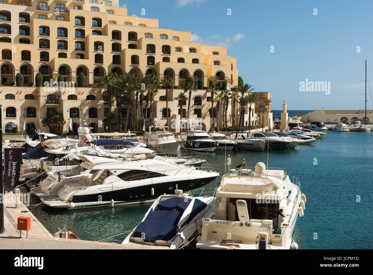 Boats moored in Portomaso Harbour St Julians Bay Malta in front of the Hilton hotel on a sunny summer day Stock Photo