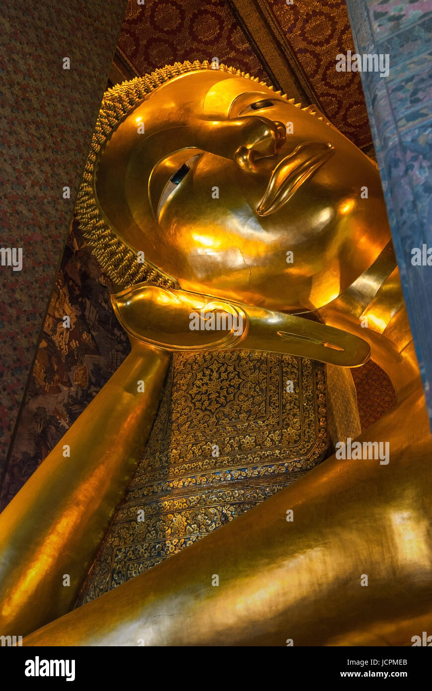 The gold leaf covered face and arm of the Laying Buddha in the Wat Pho, Bangkok, Thailand. Stock Photo