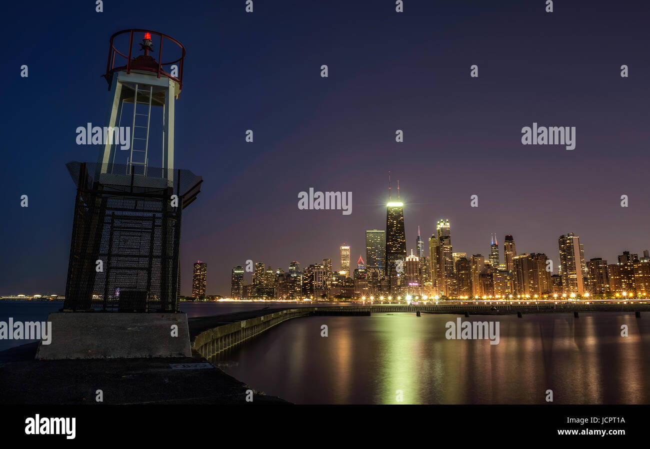 CHICAGO, ILLINOIS, USA - MAY 30, 2016 : Chicago skyline across Lake Michigan at night viewed from North Avenue Beach with a lighthouse in foreground.  Stock Photo