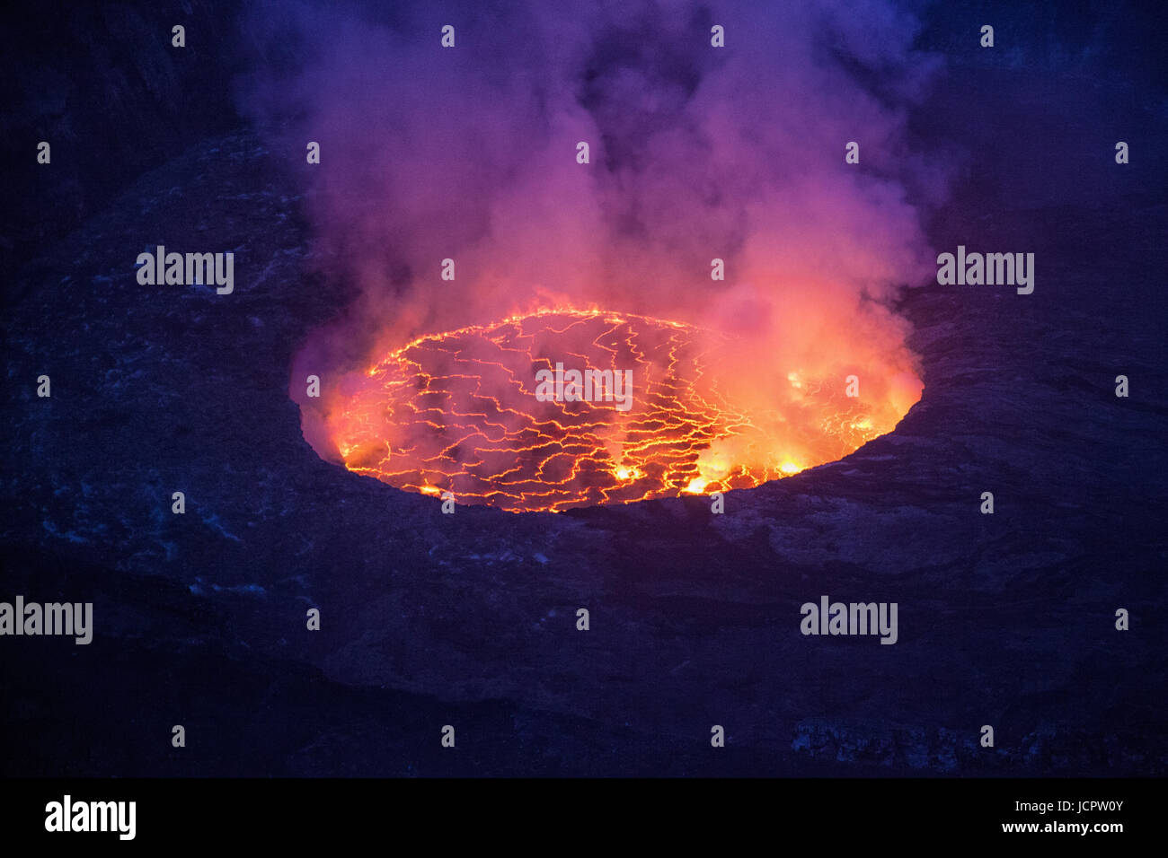 Steam rises from the biggest lava lake in the world at Nyiragongo volcano. It is one of eight volcanoes within the Virunga National Park/DR Congo. Stock Photo