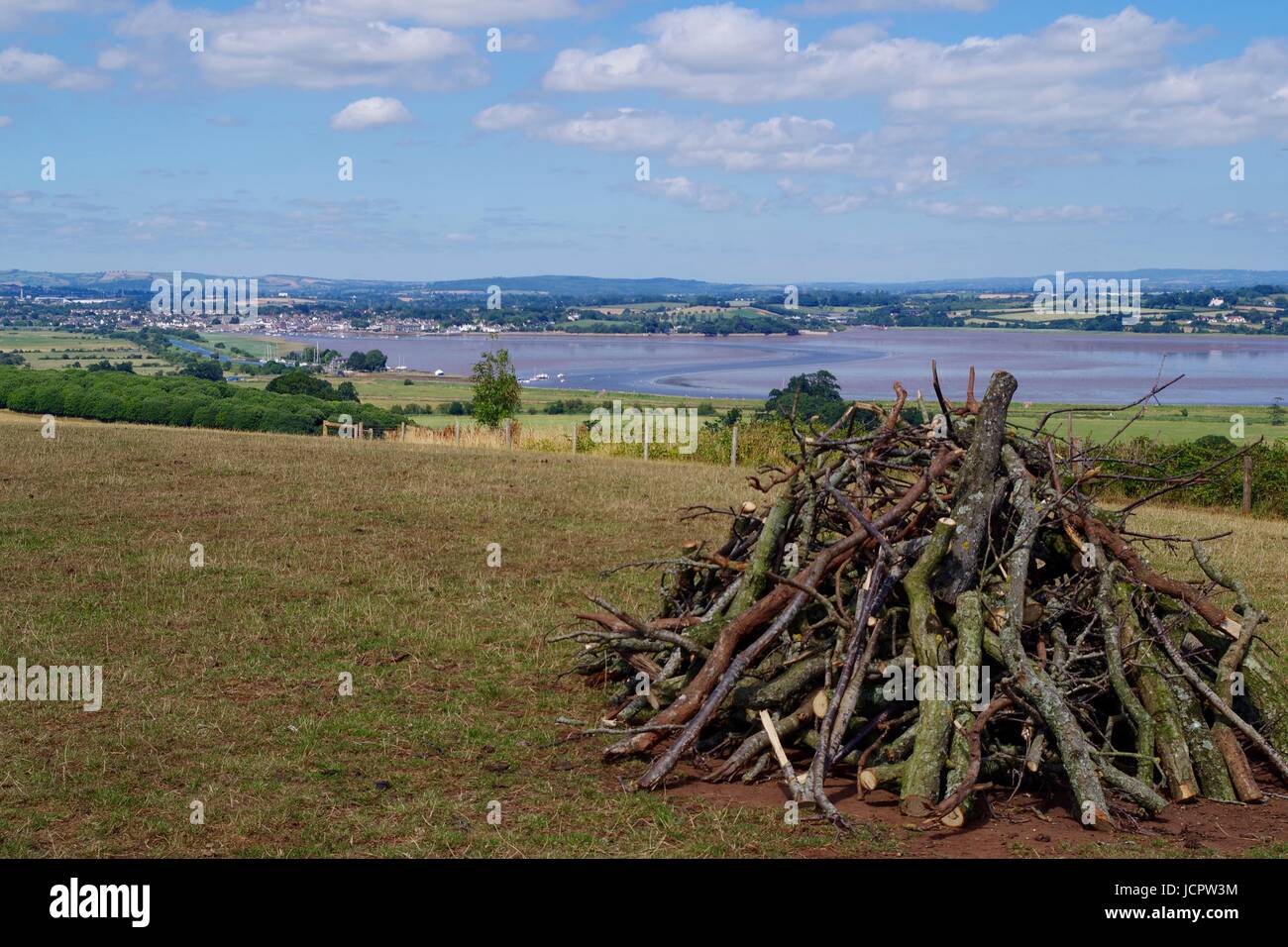 Unlit Bonfire Lay of Woodland Branches in a Field Overlooking the Exe Estuary. Powderham Castle, Devon, UK. July, 2016. Stock Photo