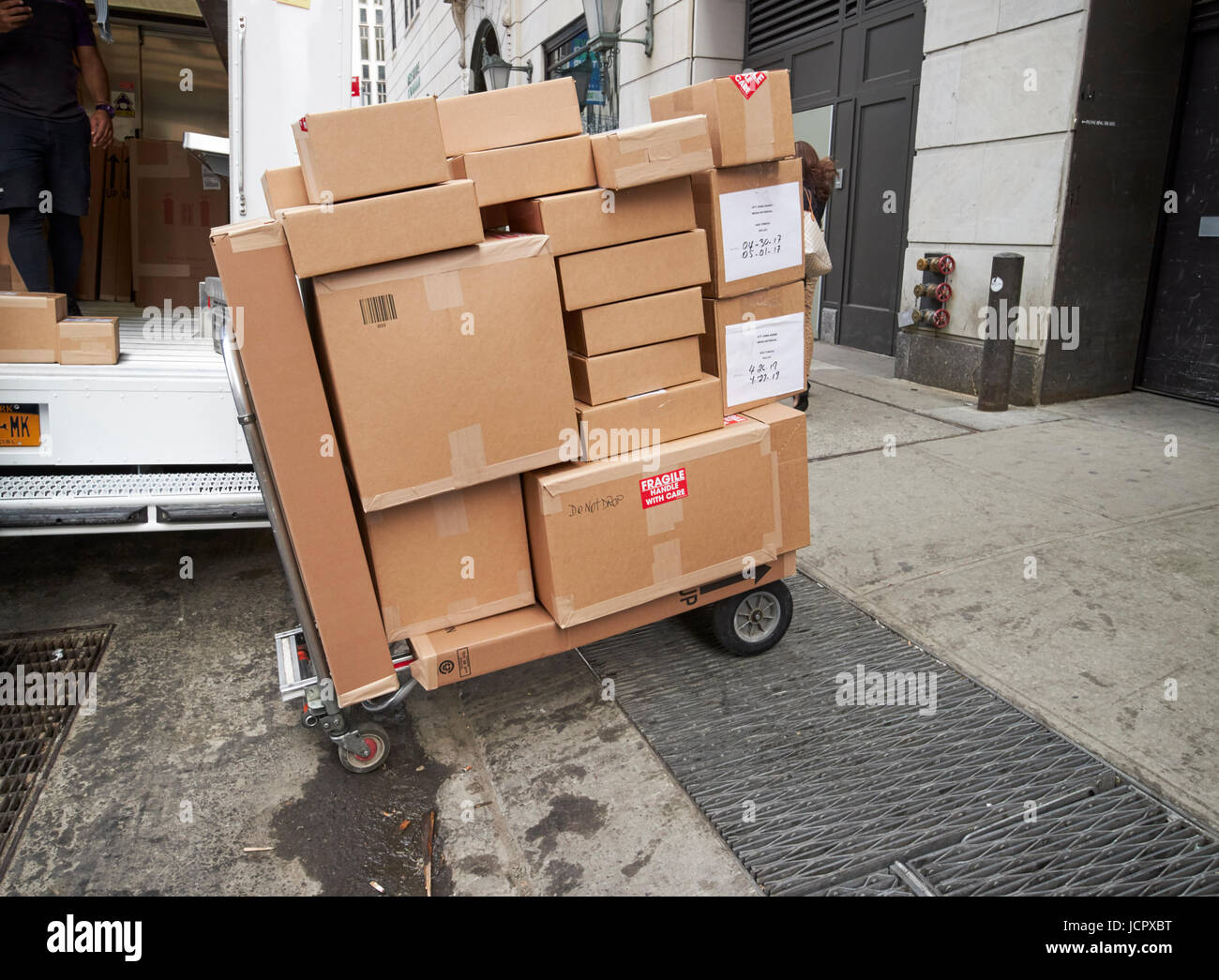 hand push delivery cart loaded with cardboard box deliveries New York City USA Stock Photo