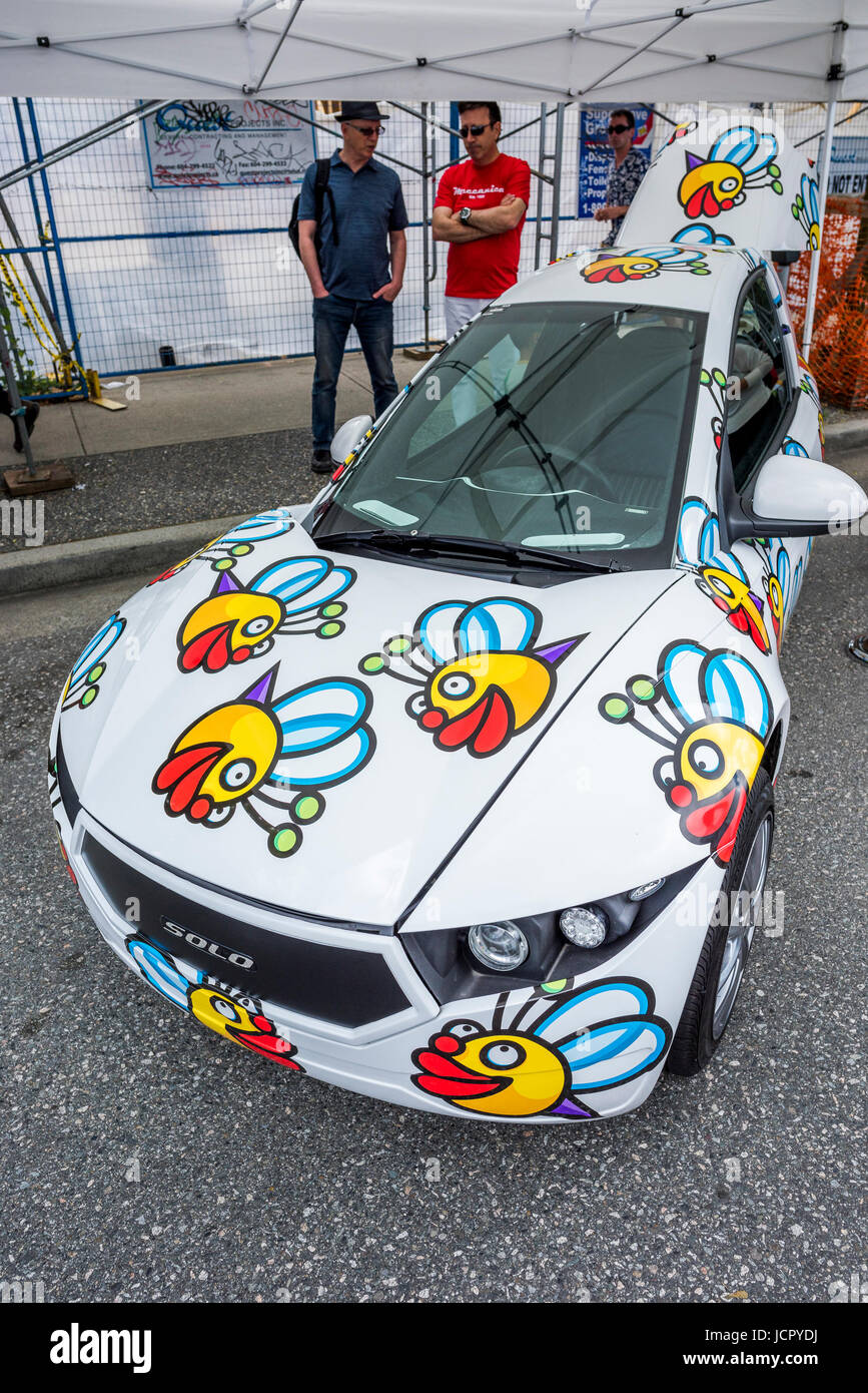 Electra Meccanica SOLO electric car featuring design by artist Joe Average, Italian Day Festival, Commercial Drive, Vancouver, British Columbia, Canad Stock Photo