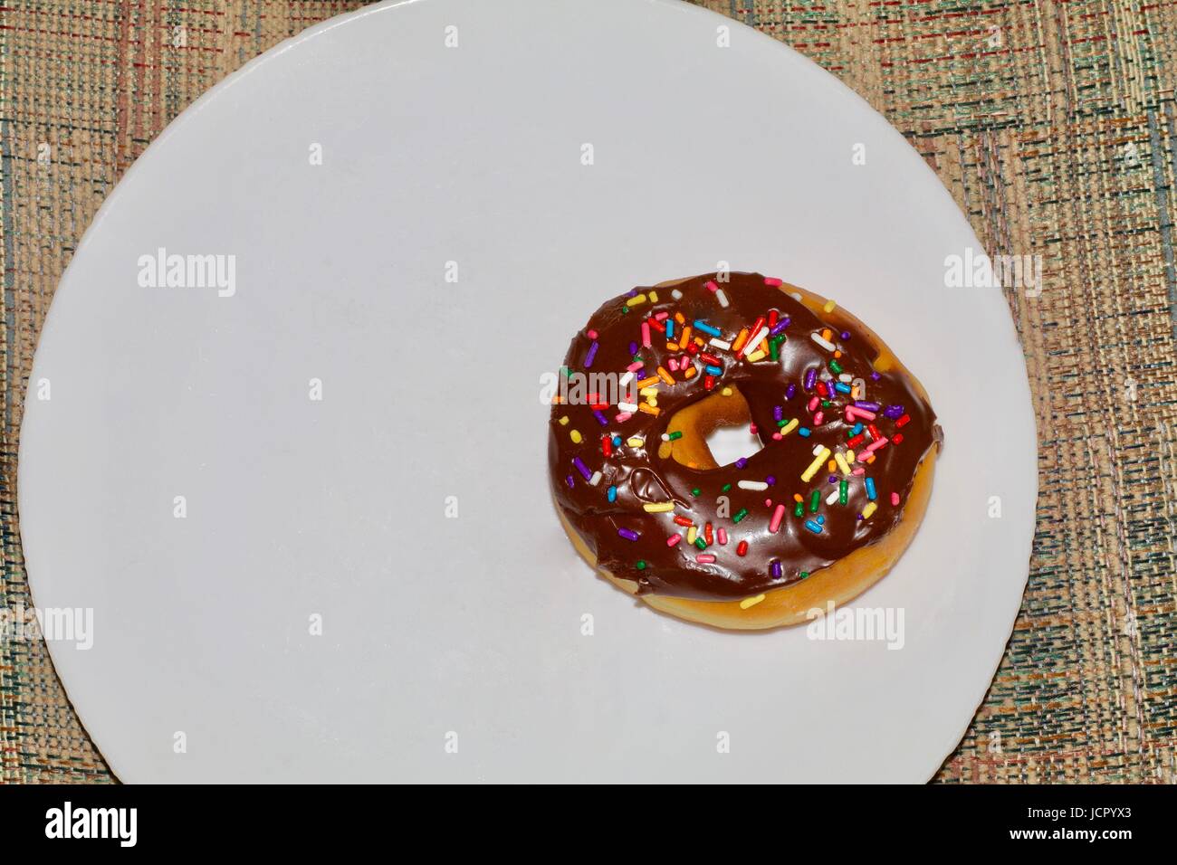 Single chocolate covered doughnut with sprinkles Stock Photo