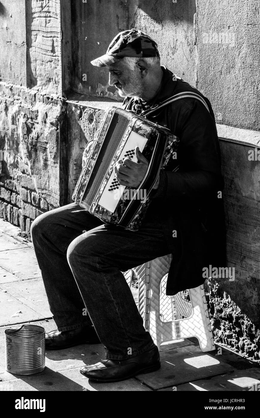 Full length portrait of a senior busker playing the accordion, Stoke Newington, London, England, UK. Stock Photo